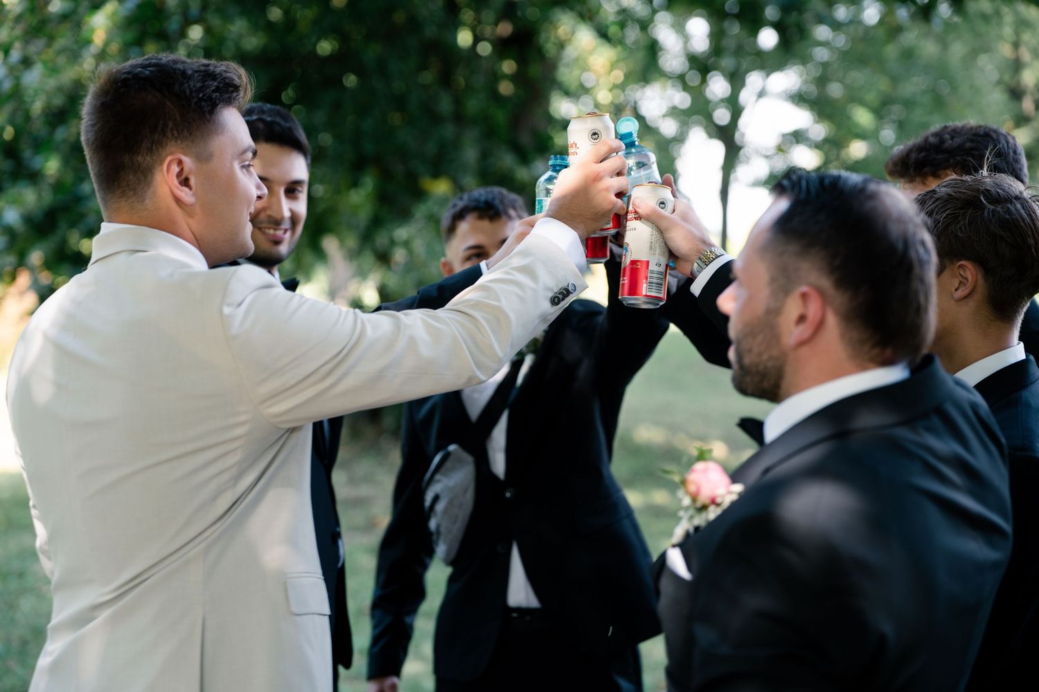 Wedding party members celebrate outdoors in formal attire.