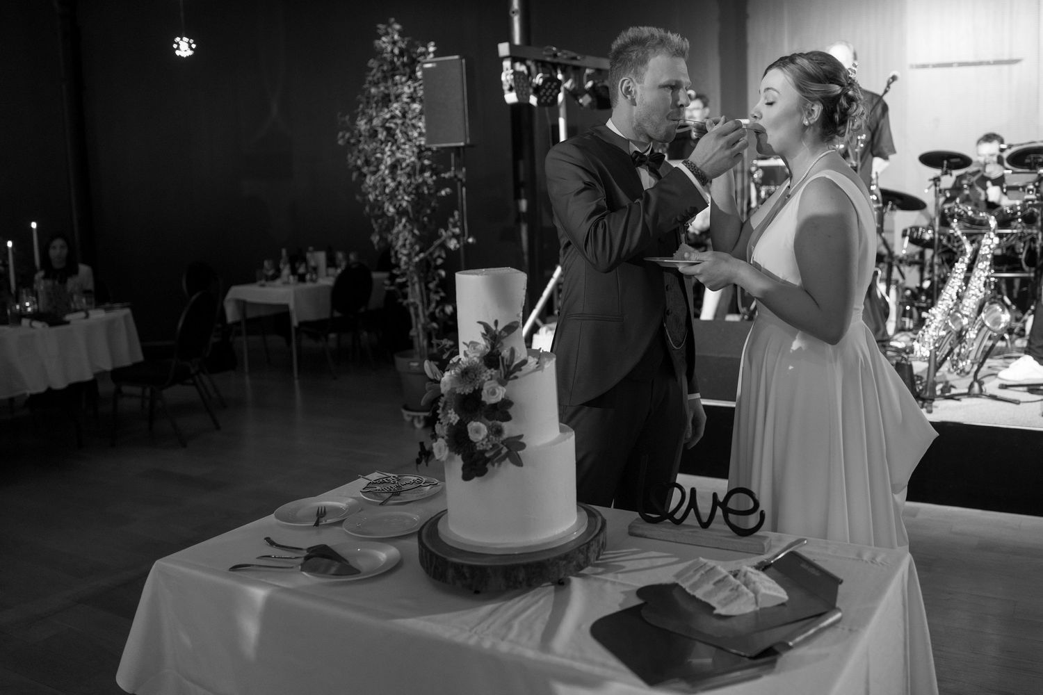 Black and white reception photos showing wedding cake and dancing celebrations.