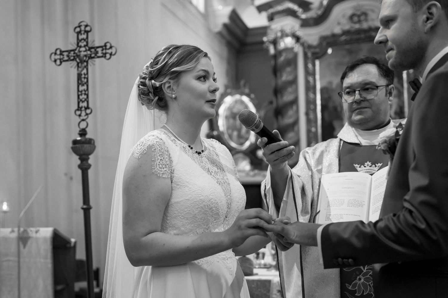 Black and white photo of a church wedding ceremony with ornate crosses visible.