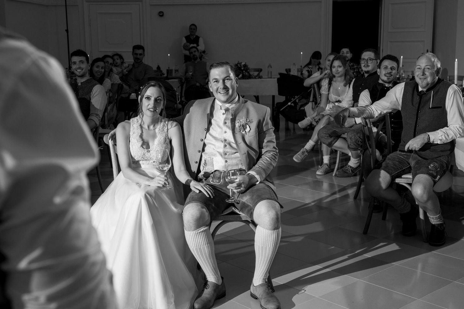 Black and white photo of wedding guests watching the couple's first dance from their seats.