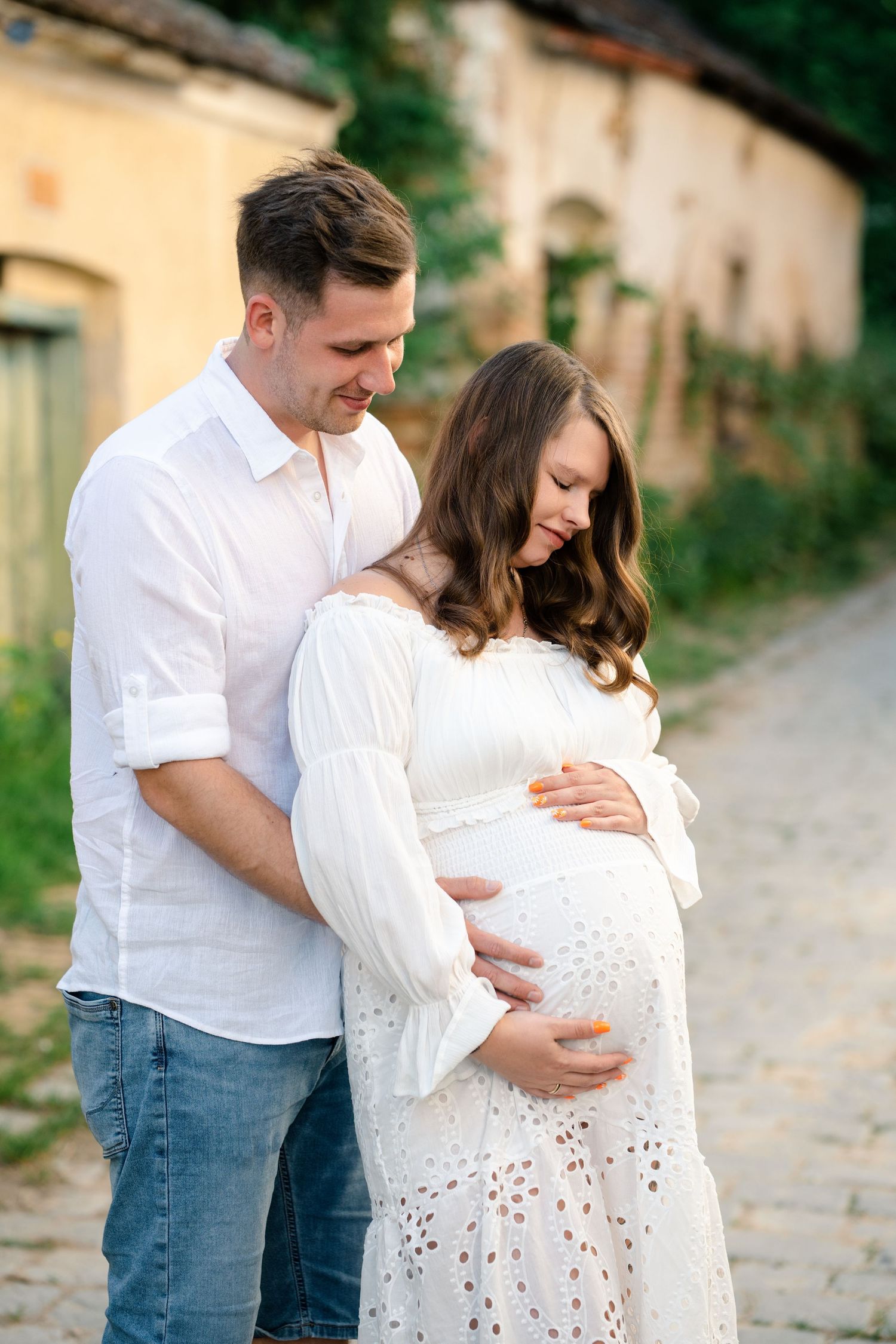 A couple embraces tenderly on a rustic stone path during a romantic outdoor photo session.