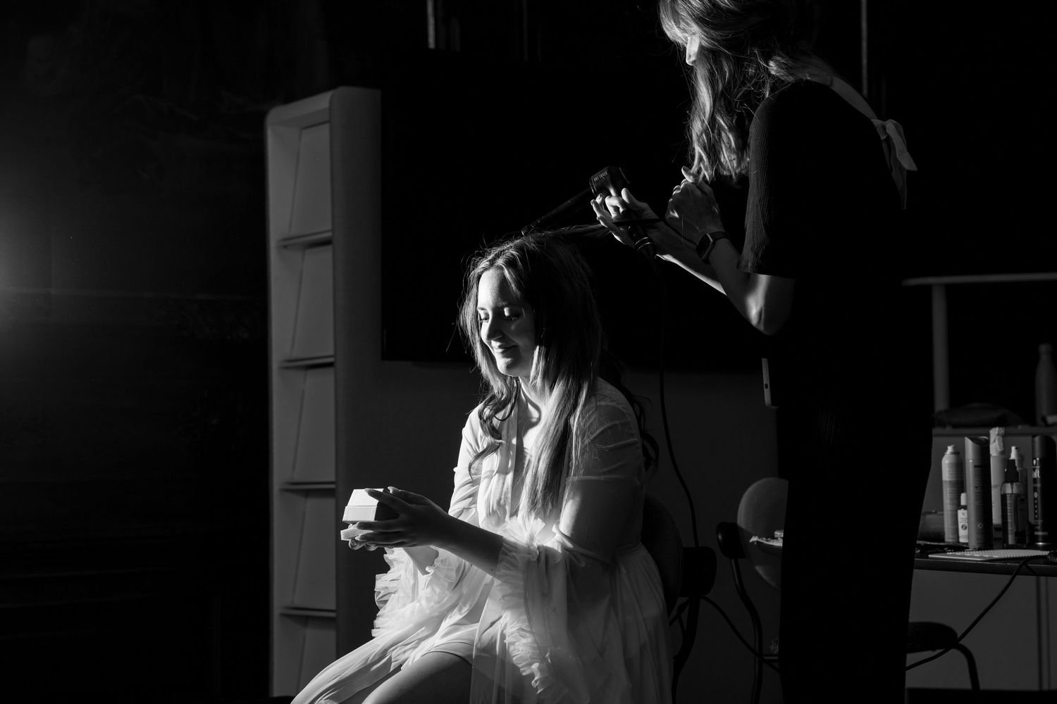 Artistic black and white photography captures intimate wedding preparation moments.