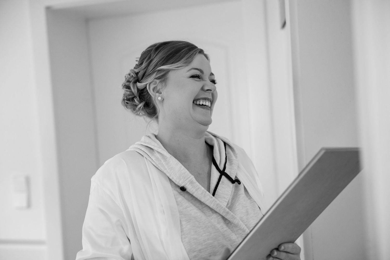 Wedding preparation scene with people getting ready in a bright white room.