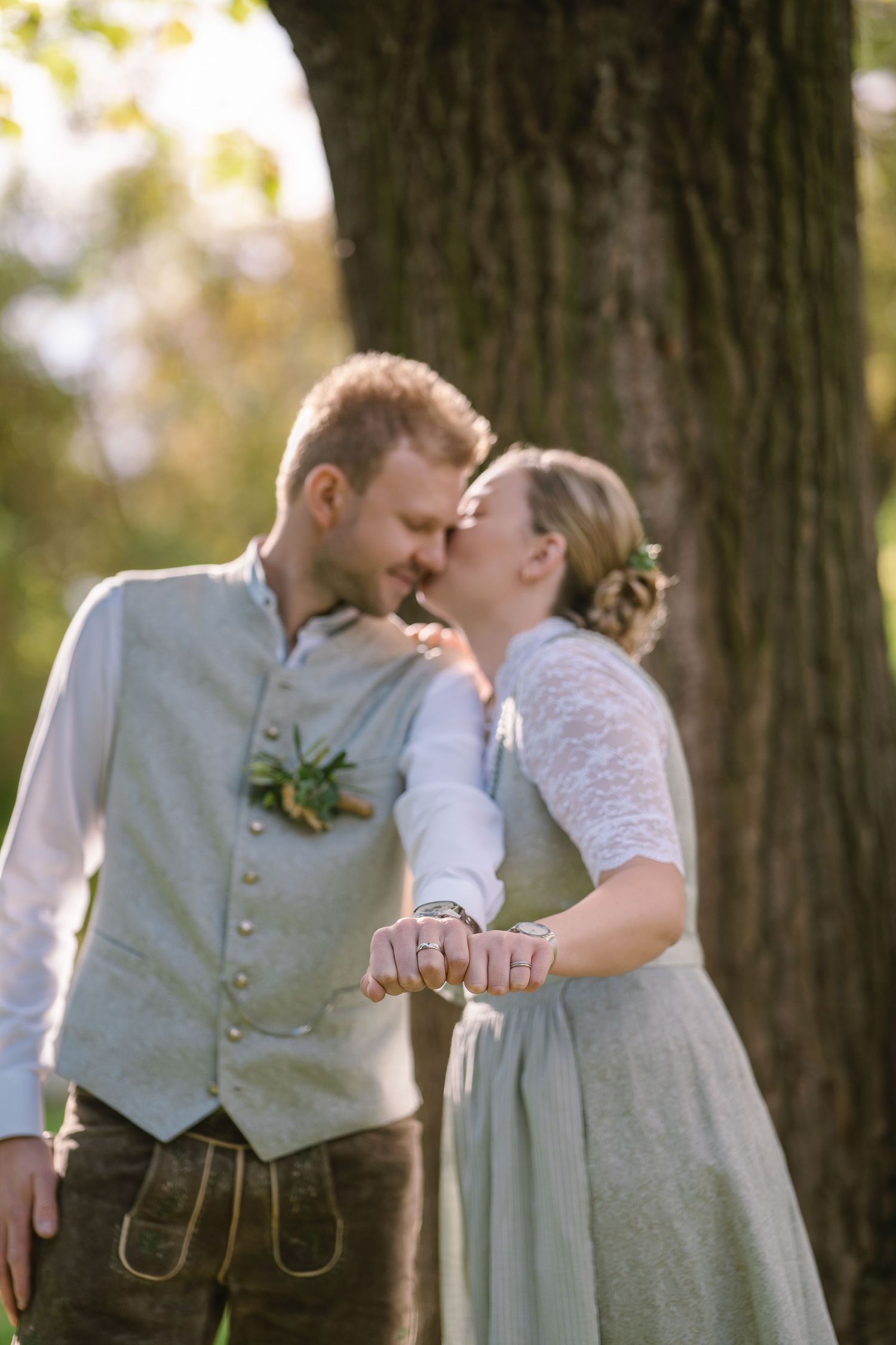 Romantic couple in vintage-inspired attire share intimate moments in a series of photos against a backdrop of trees.