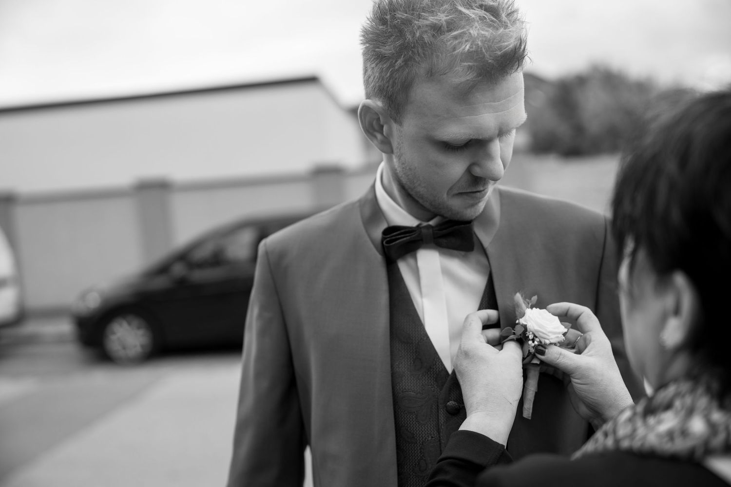 Formal wedding party members in black tuxedos and suits preparing for ceremony.
