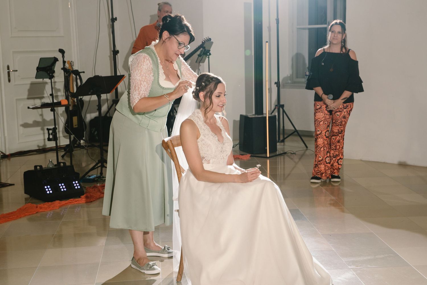 Wedding reception scene with guests dancing in a bright indoor venue.