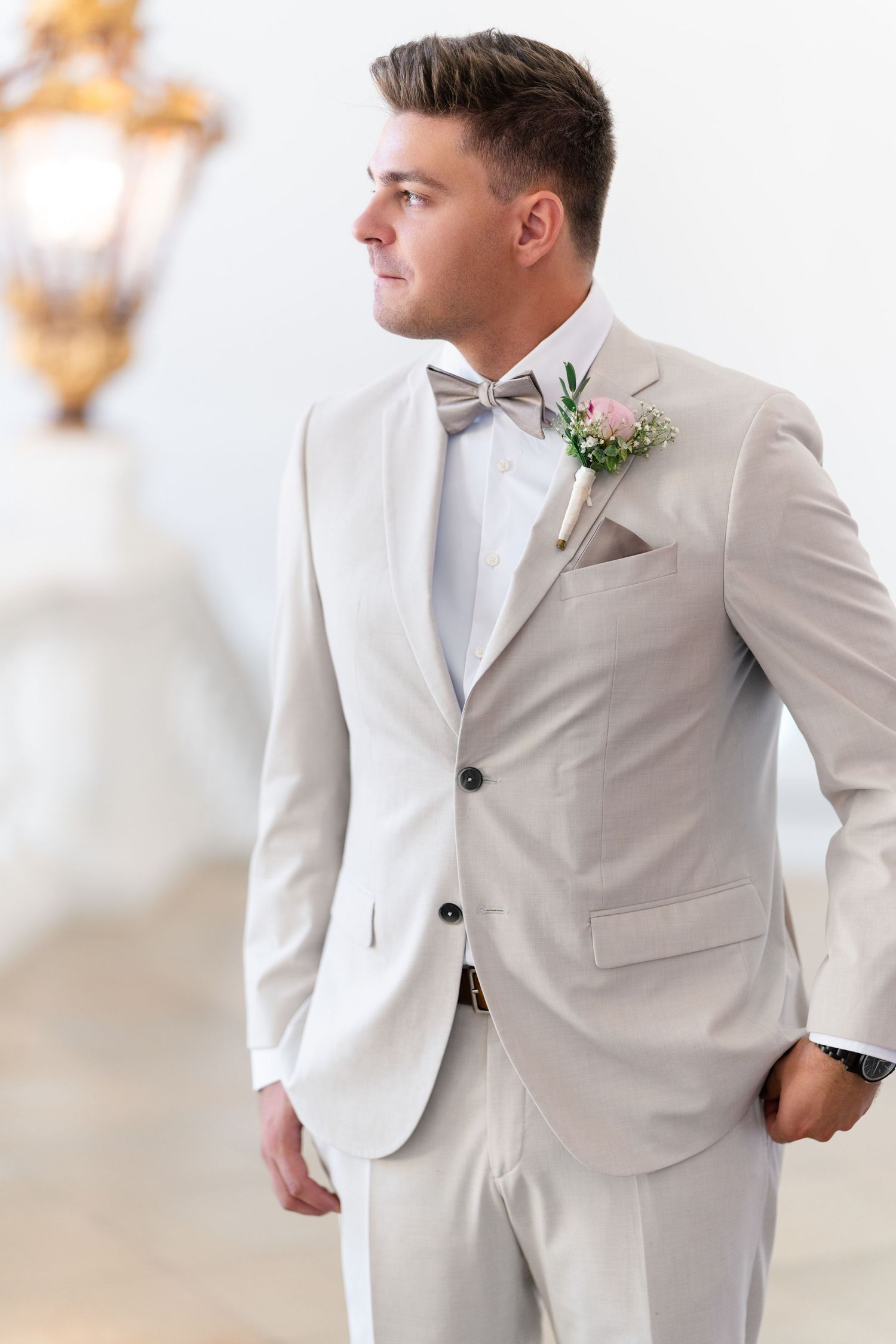 Formal portrait of person in light gray suit with bowtie and boutonniere.