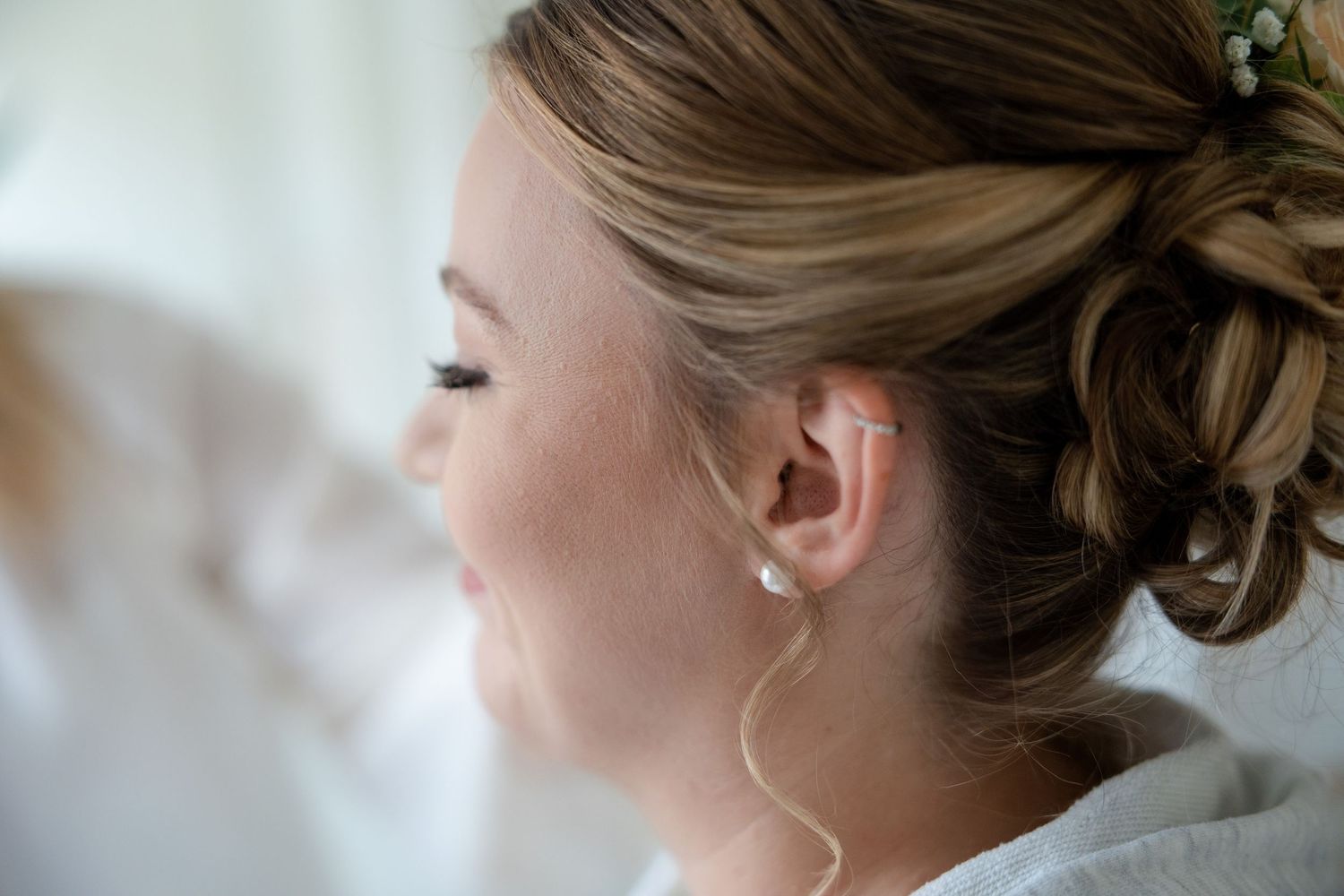 Bride getting ready with hair styled in an elegant updo for her wedding day.