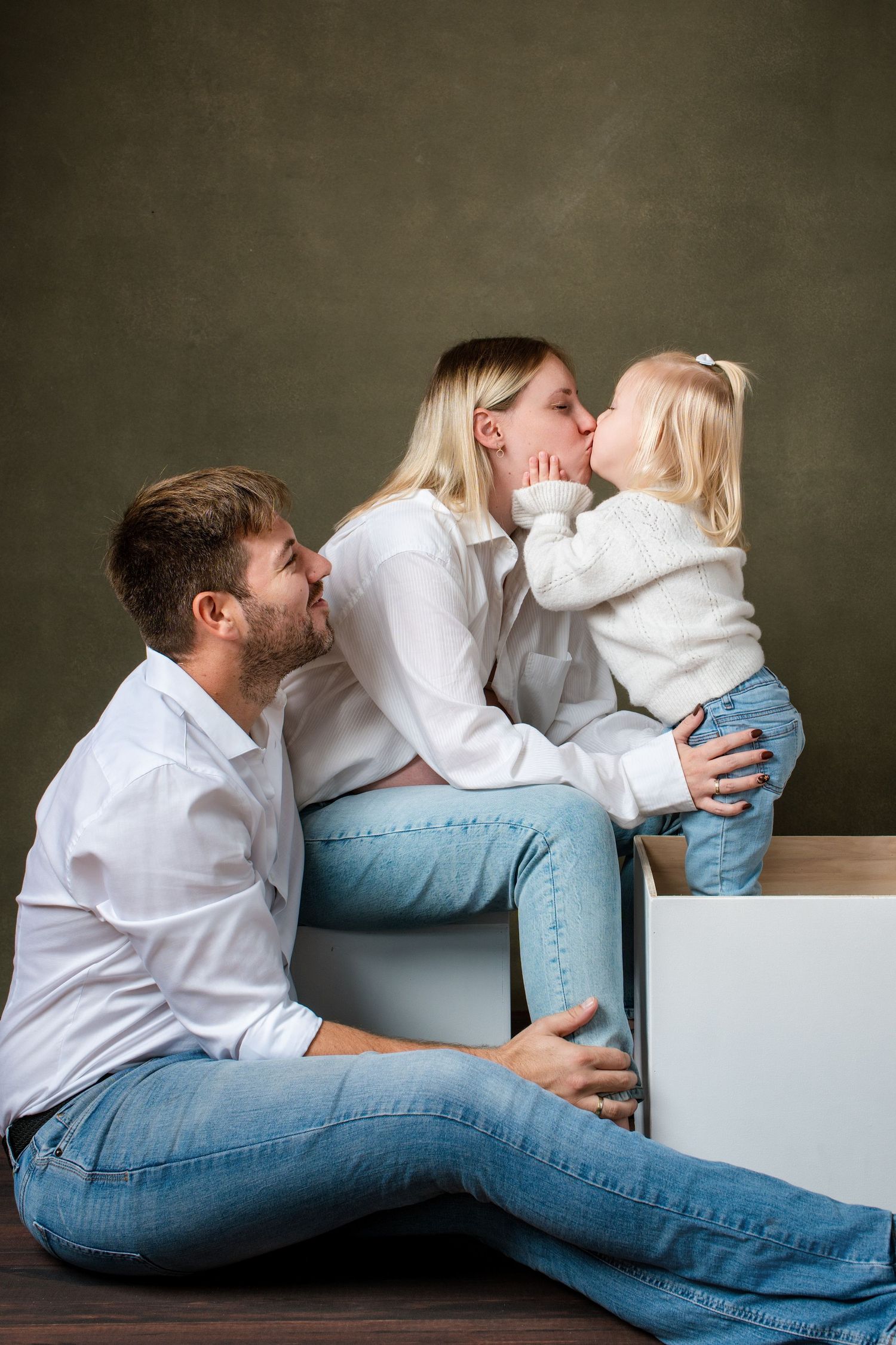 Casual lifestyle portraits showing tender moments between family members on white furniture.