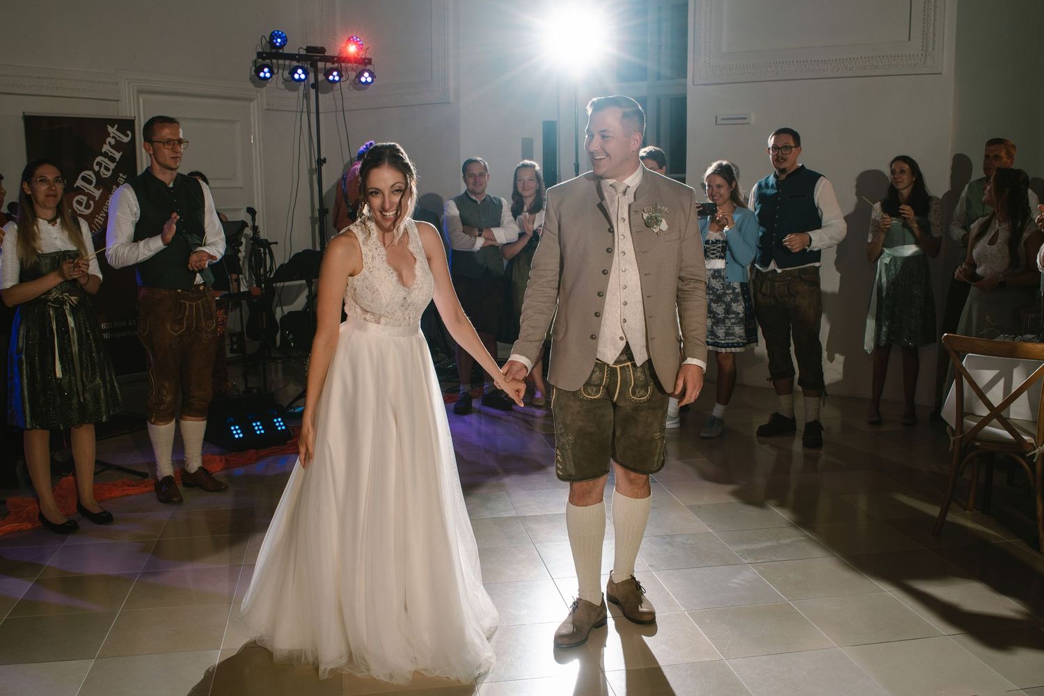 Wedding reception dance floor with red and blue lighting as couple performs their first dance.