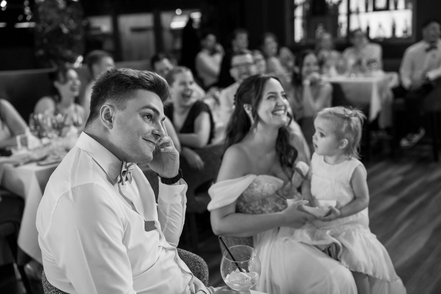 Wedding guests laughing and enjoying themselves during a reception celebration.