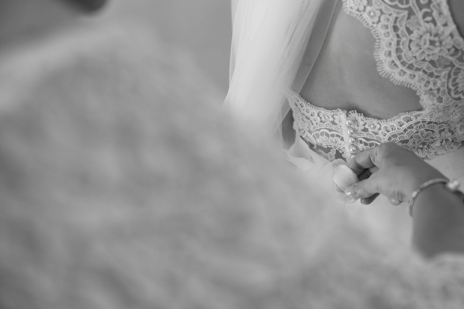 A close-up detail shot of white lace wedding dress fabric.