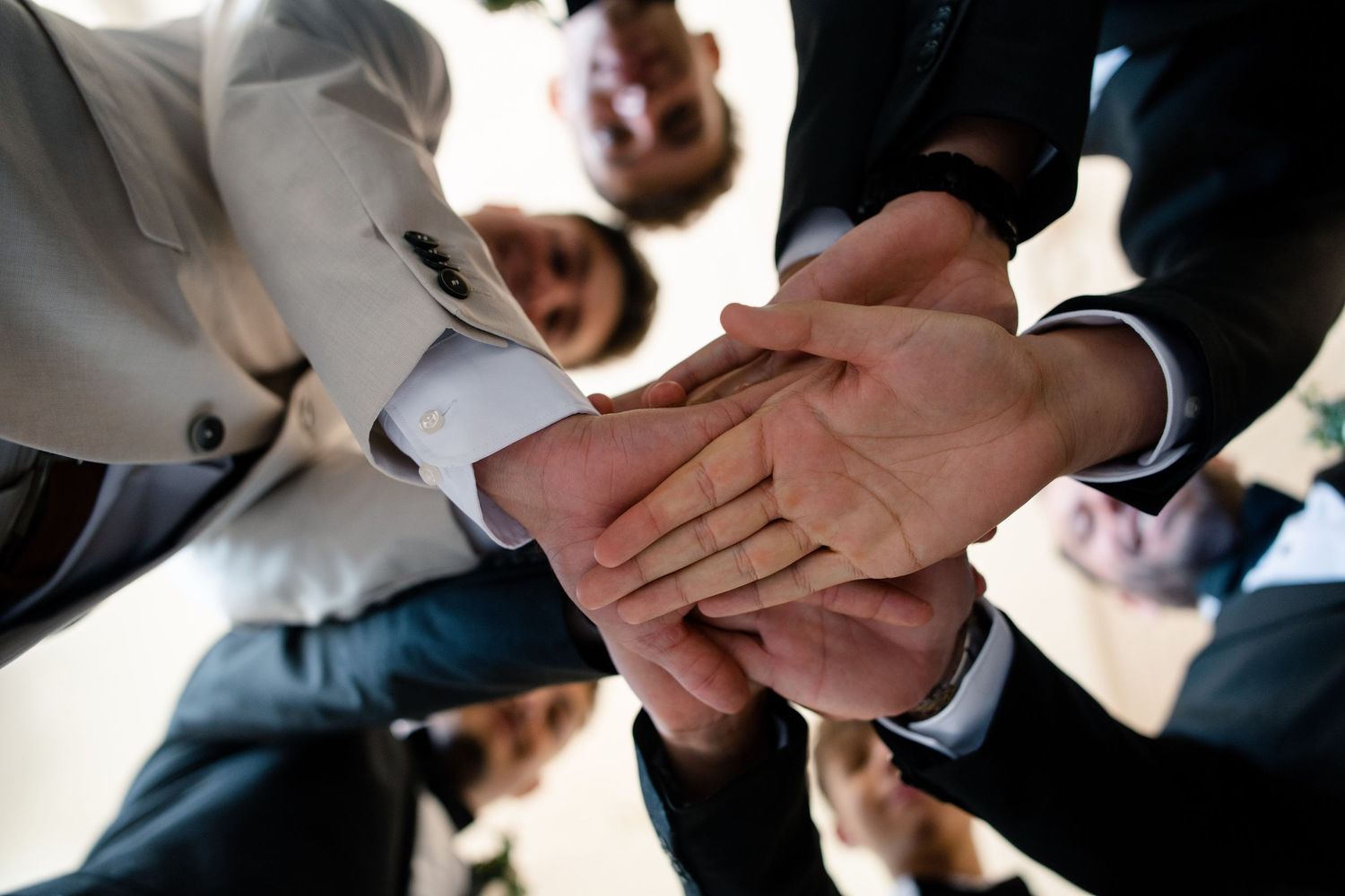 Wedding party members join hands in a circle formation during celebration.