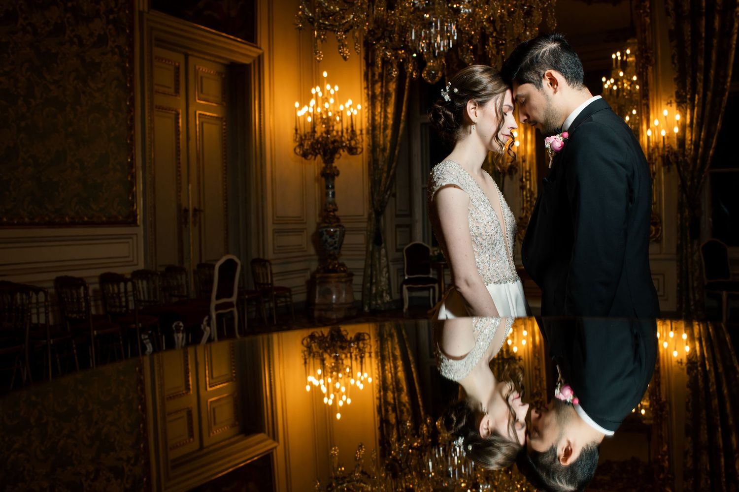 A romantic couple dances in an elegant ballroom with ornate chandeliers and golden lighting creating a dreamy atmosphere.