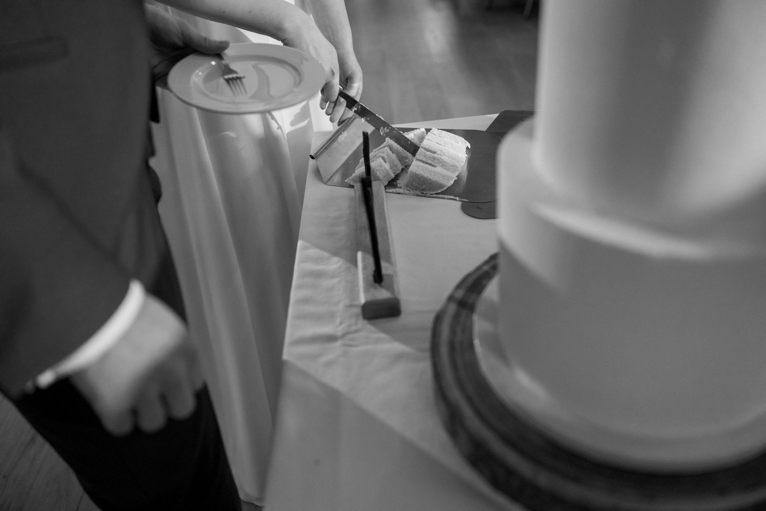 Close-up black and white shot of lighting a unity candle during ceremony.