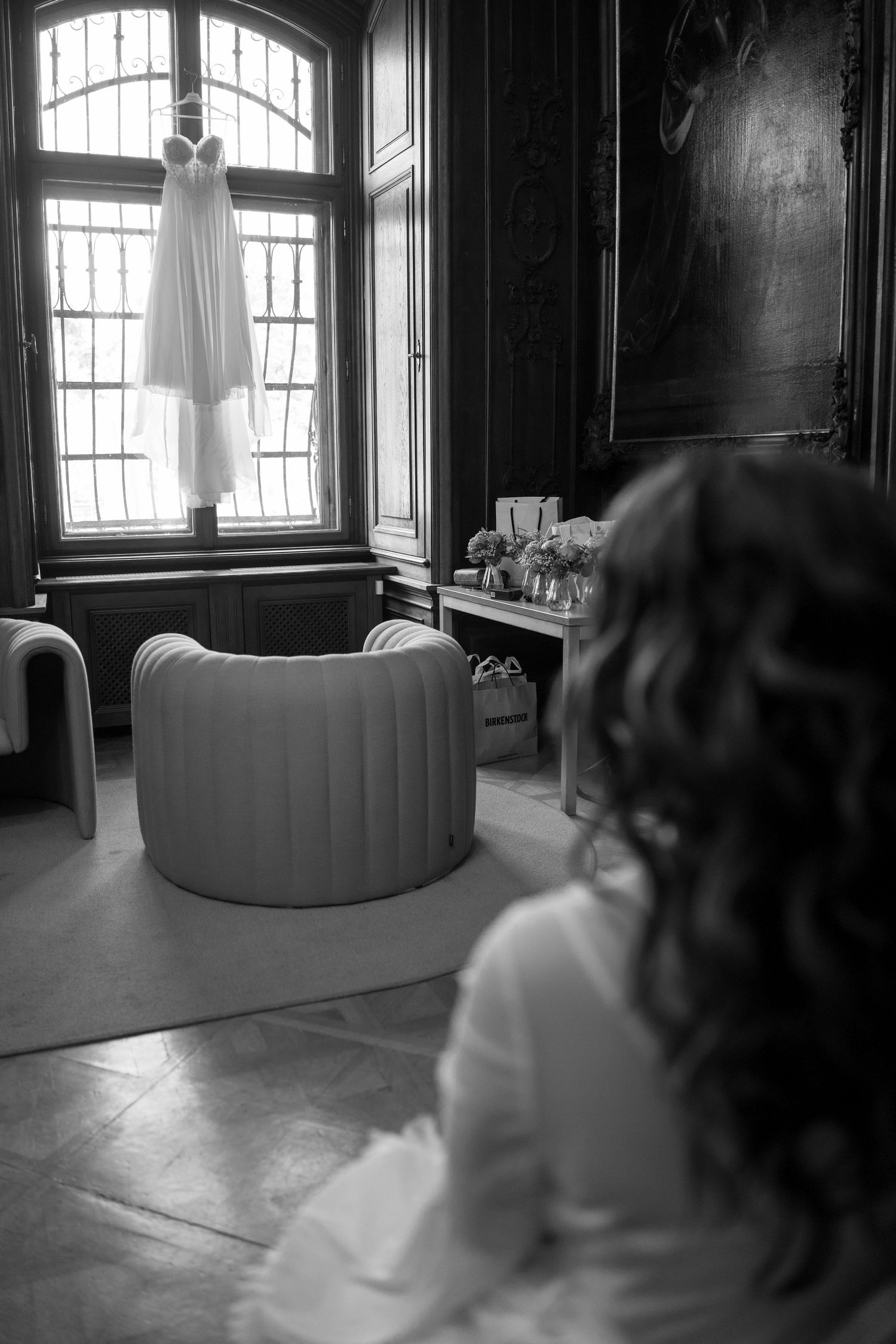 Black and white photo of an elegant room with arched windows and dramatic lighting.