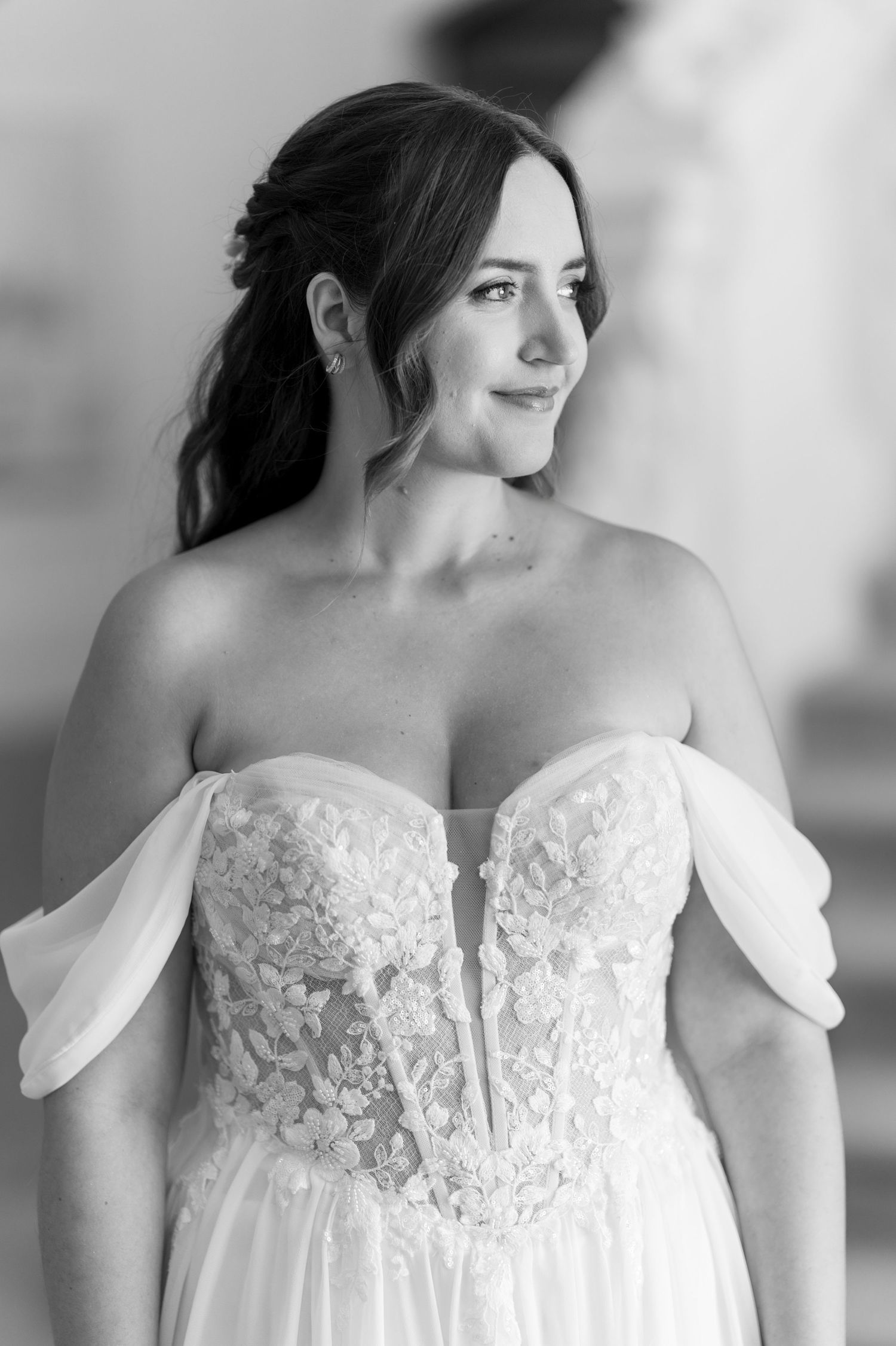 Close-up details of white lace bodice on off-shoulder wedding dress.