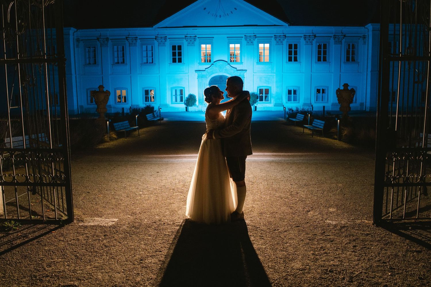 Historic building illuminated in dramatic blue lighting creates romantic nighttime atmosphere.