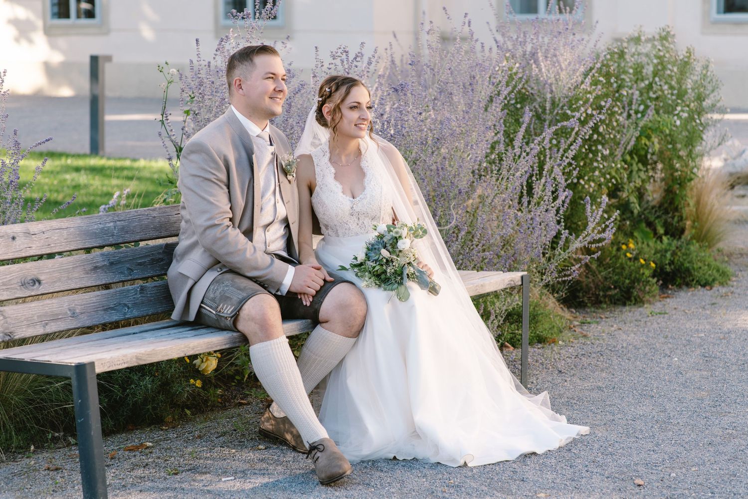 A romantic wedding photo session on a rustic bench with a couple in traditional Bavarian attire.