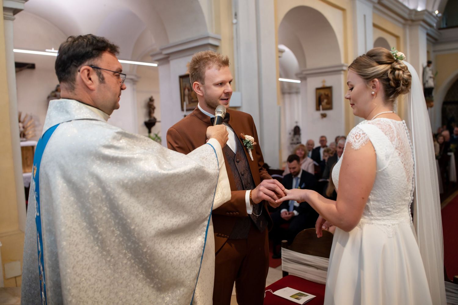Elegant church wedding ceremony with guests gathered in ornate cathedral interior.