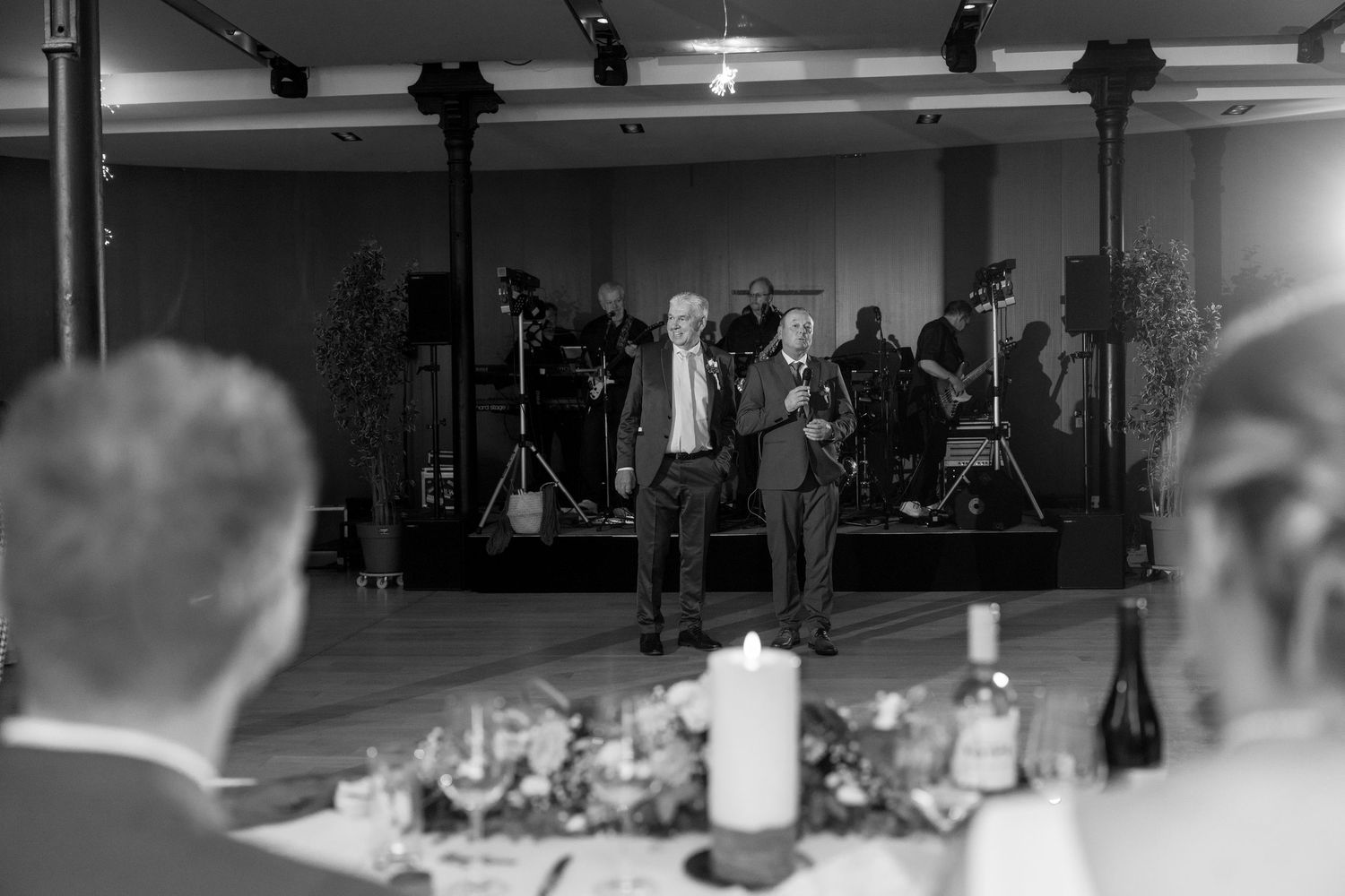 An atmospheric black and white shot of an elegant wedding reception dinner setup.