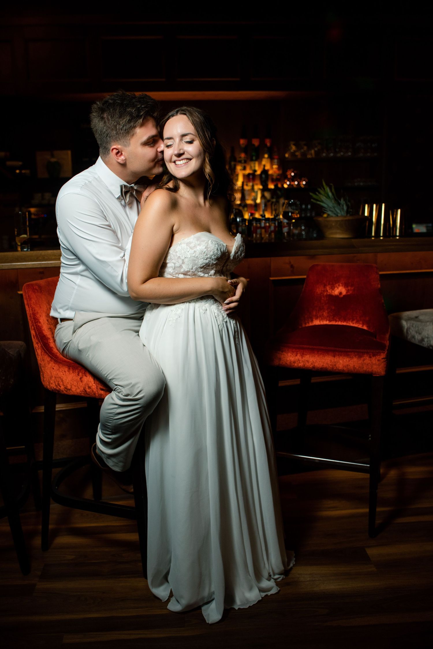An intimate portrait of newlyweds sharing a moment at an elegant bar.