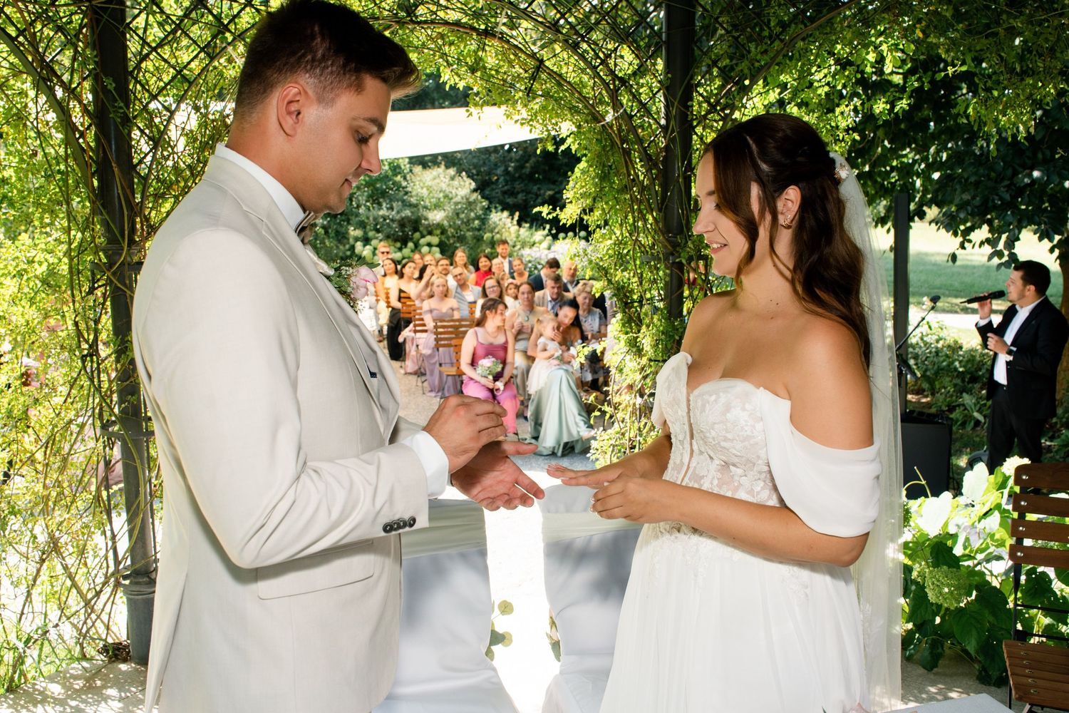 Couple sharing personal vows during an outdoor summer wedding celebration.