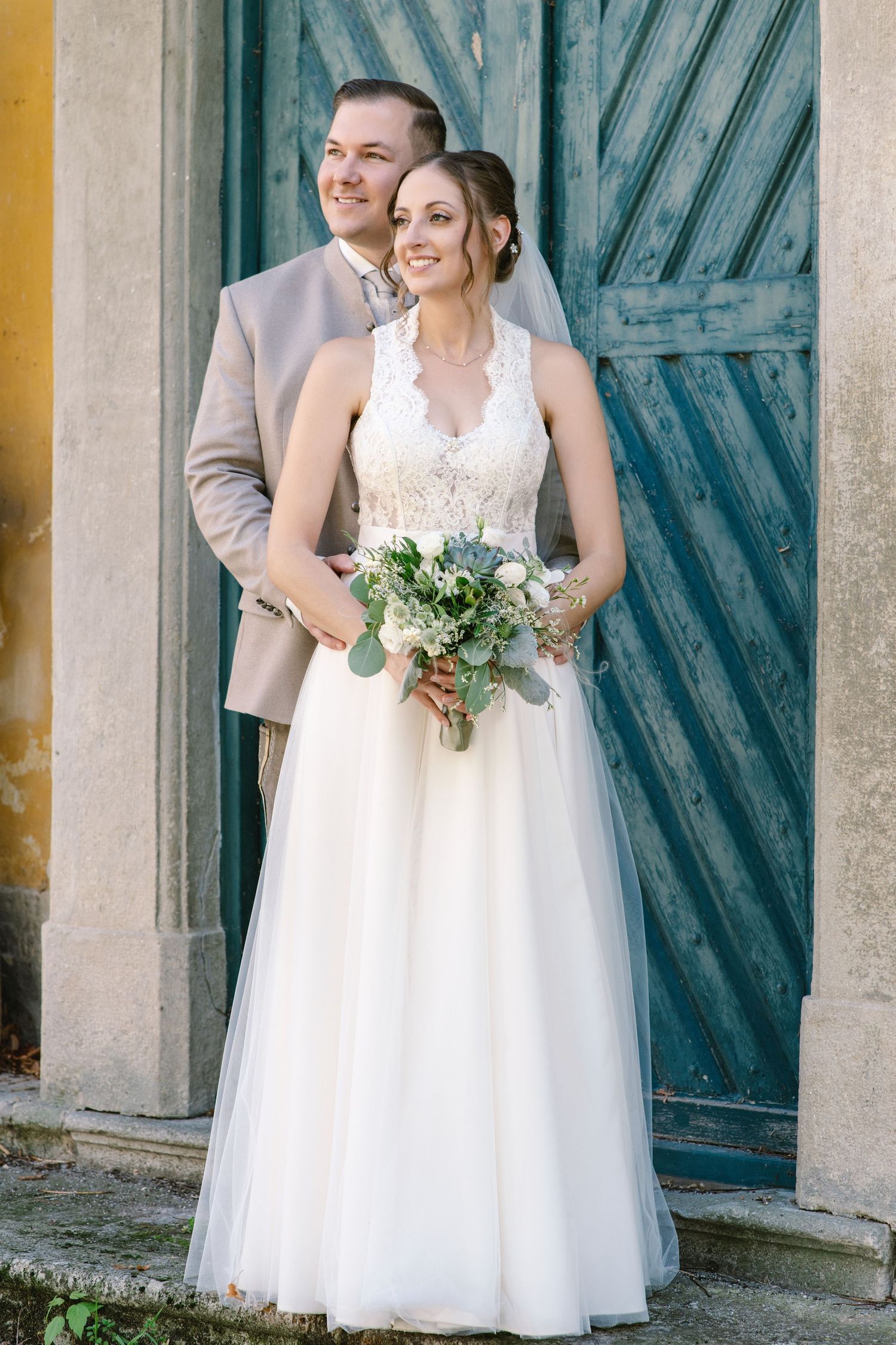Wedding portraits against a rustic blue door and yellow wall backdrop.