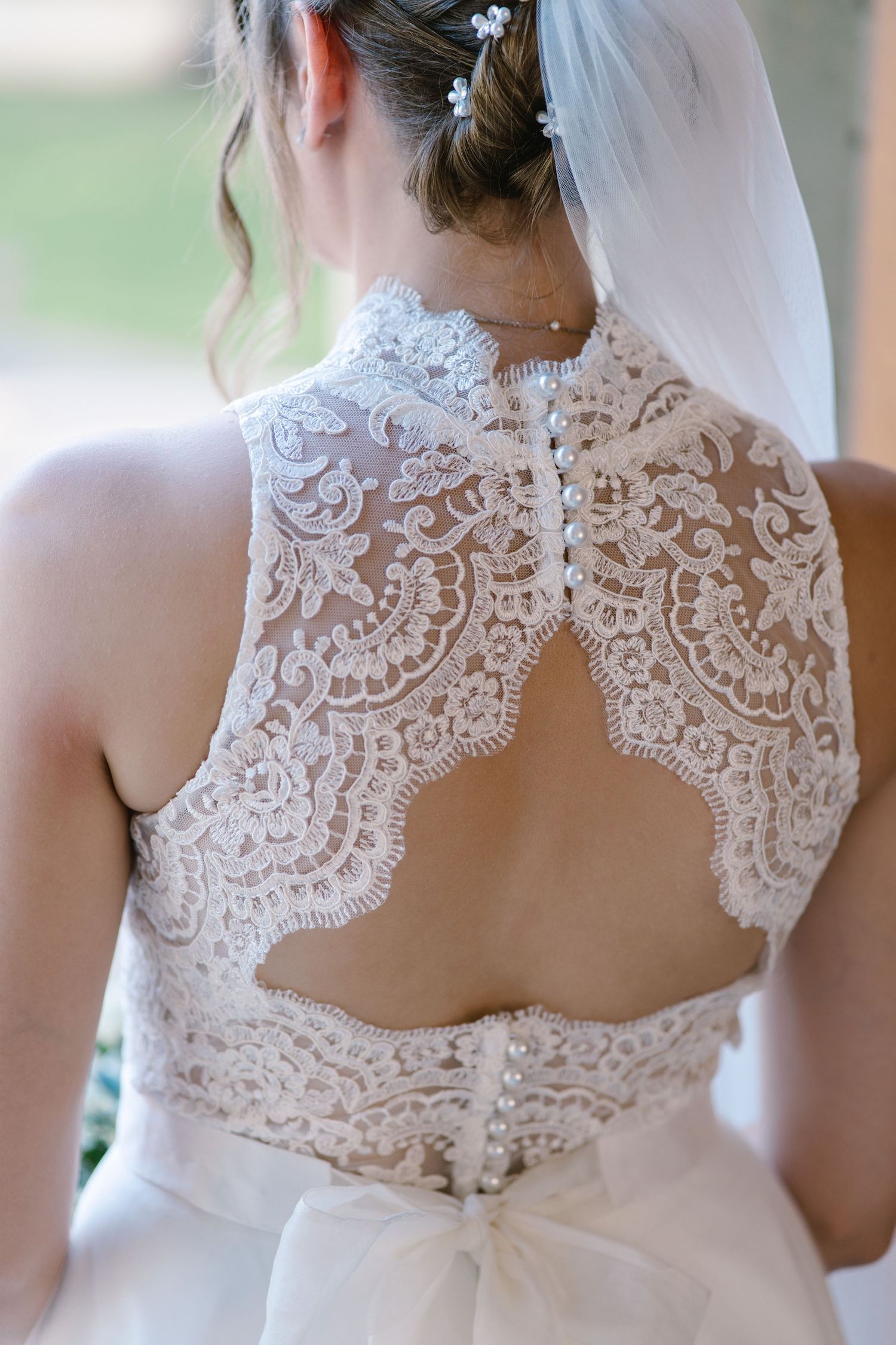 Intricate lace detail on back of white wedding dress with keyhole opening.