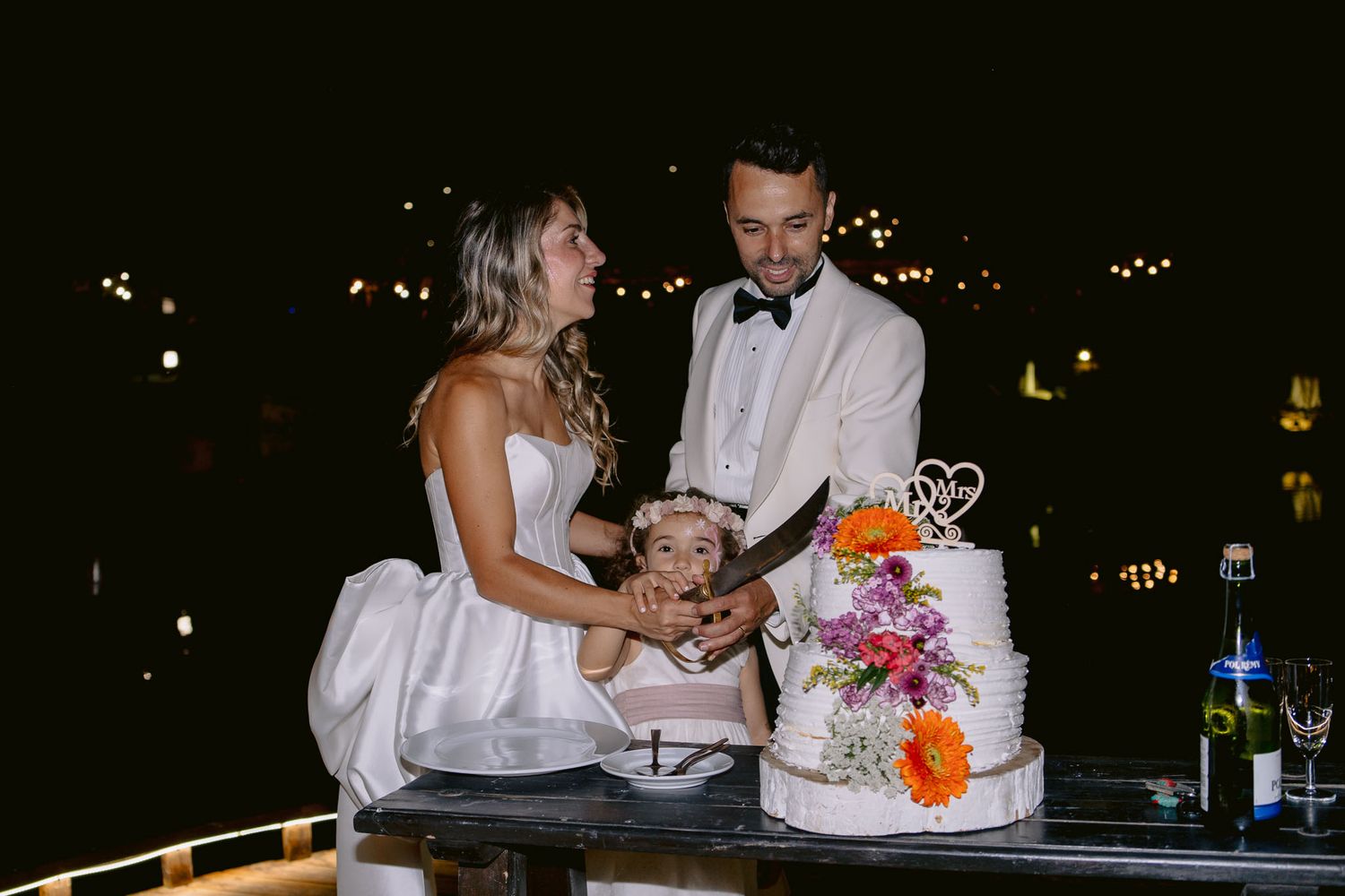 Casal celebrando o corte do bolo no casamento em Portugal, sorrindo enquanto partilham o momento