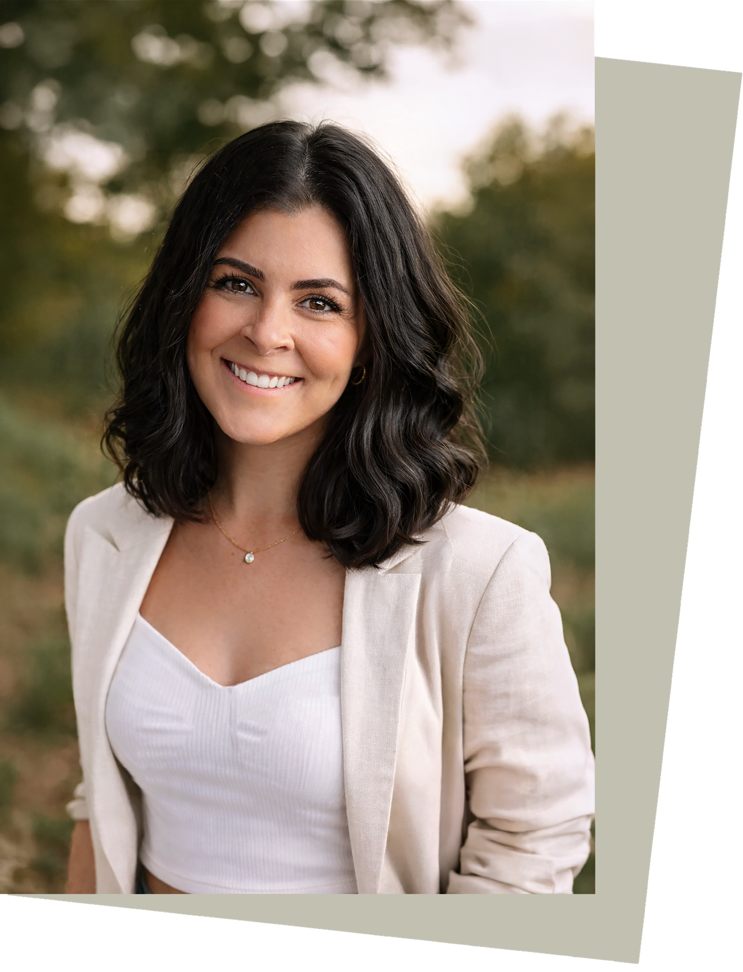 Professional portrait session featuring a white blazer and sweetheart neckline against a soft outdoor background.