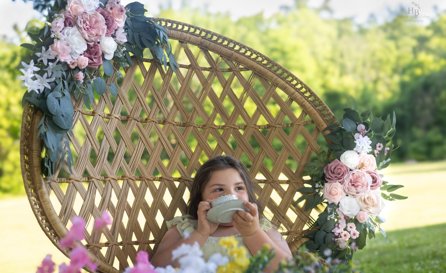 Bride in a white dress sitting in a floral-decorated rattan peacock chair outdoors, wearing a face mask.