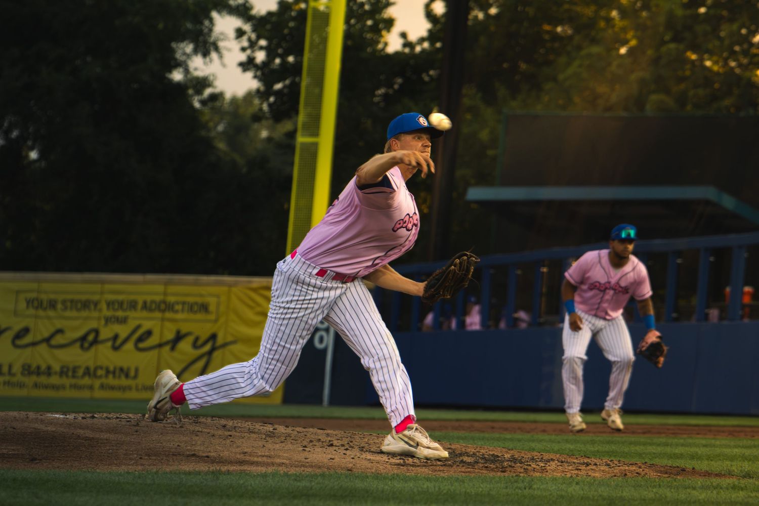 pitching ball in motion, sun hitting player