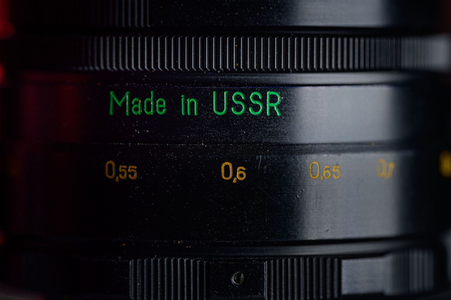Close-up of vintage camera lens engraved with Made in USSR text on black barrel.