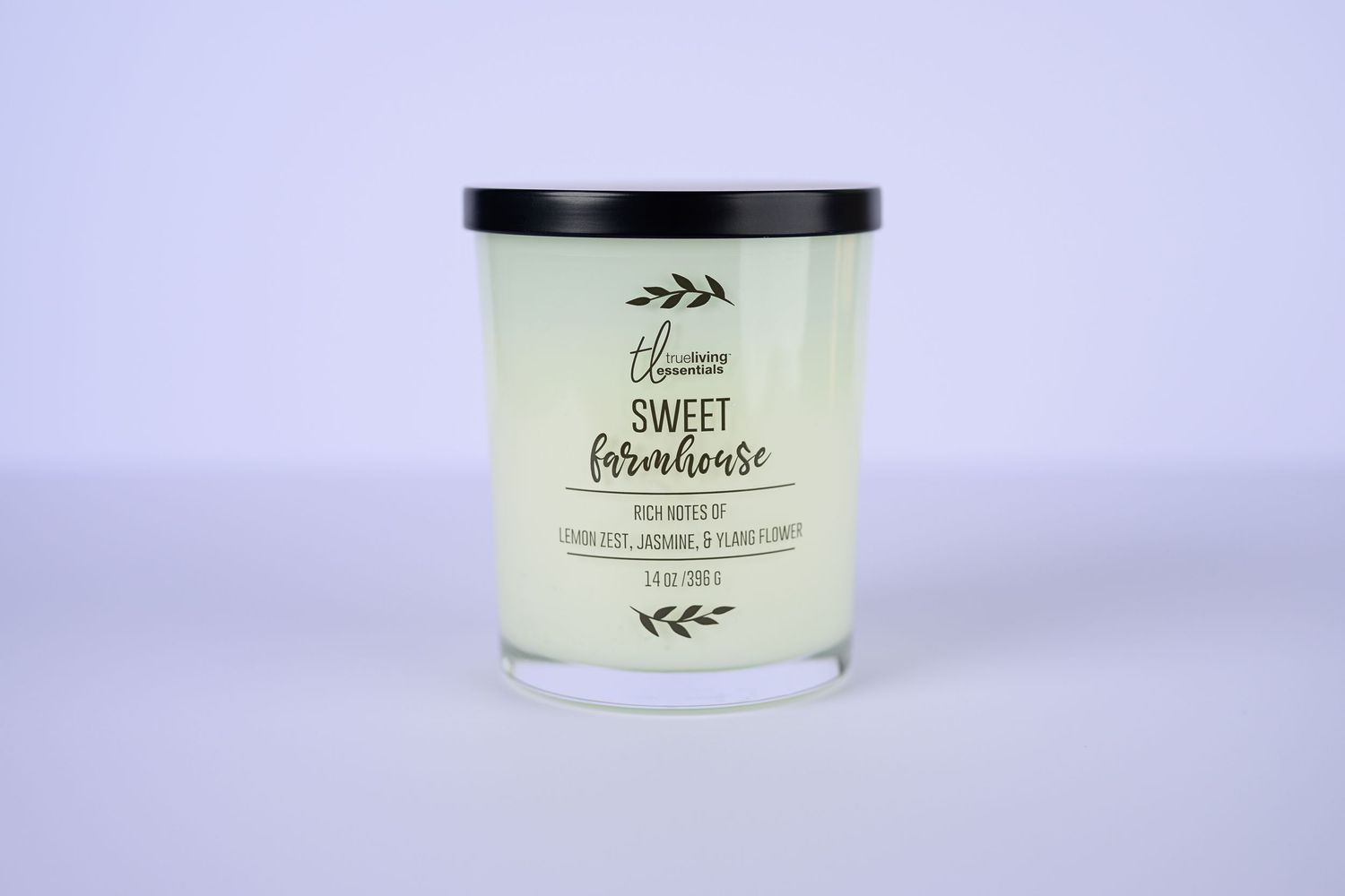 Sweet Farmhouse scented soy candle in clear glass jar with black lid on white background.