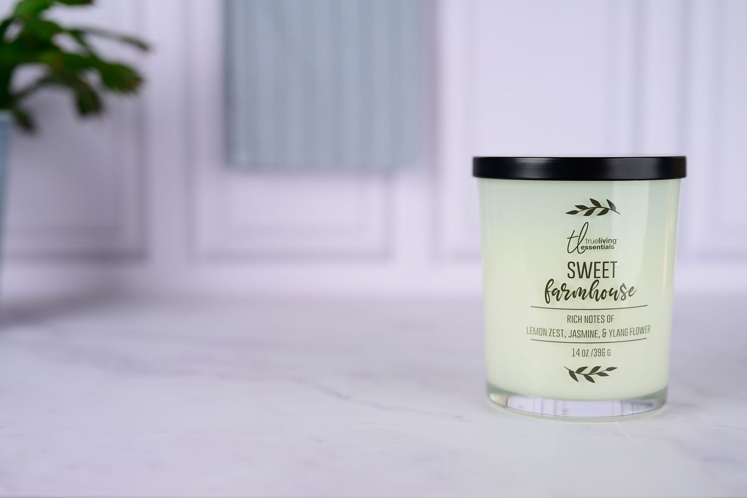 Sweet Farmhouse scented soy candle in glass jar on marble surface.