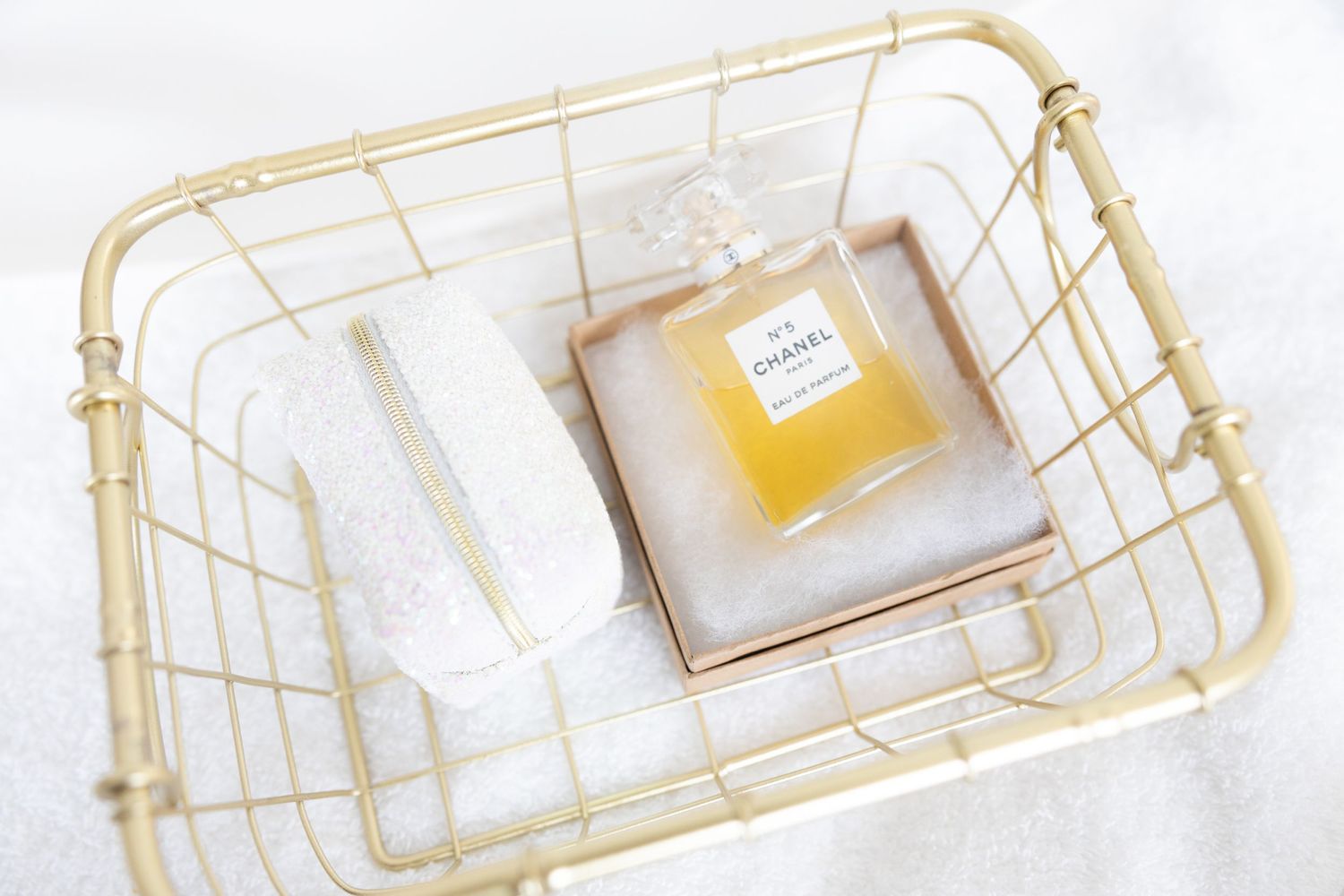Gold wire baskets containing wedding items photographed in bright, minimalist style.