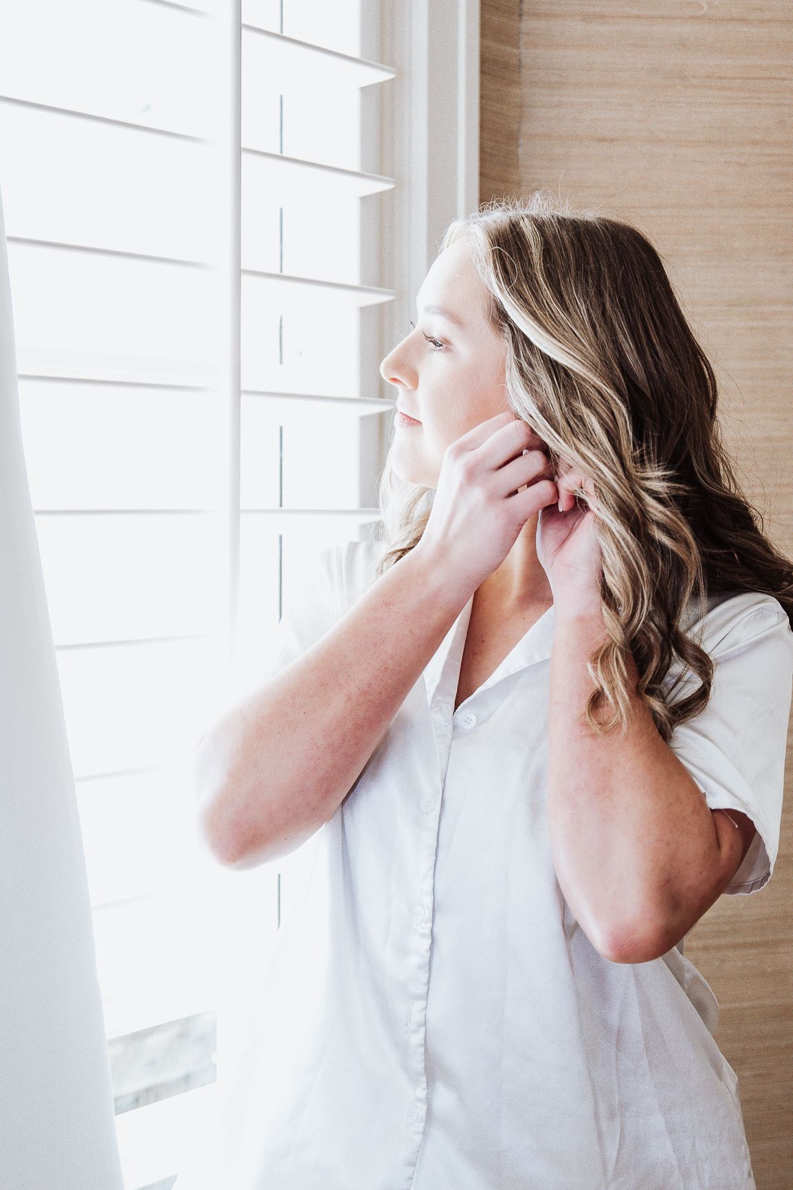 A series of four profile views showing a person in white against a bright window throwing their head back laughing.