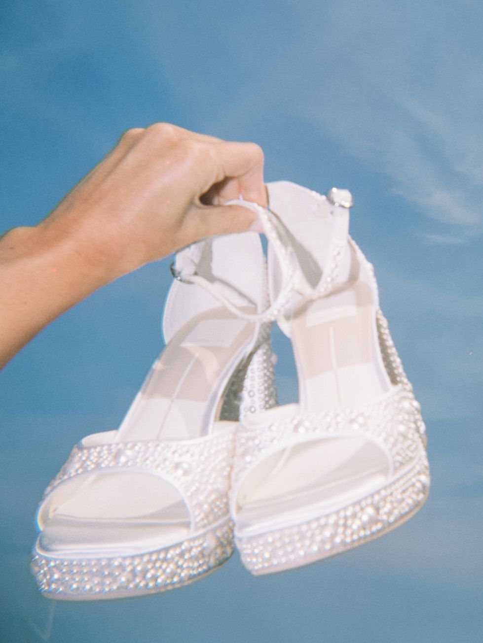 Pearl-embellished platform wedge sandals against a blue sky. Cape Cod Wedding. Wychmere Beach Club Wedding Photographer.
