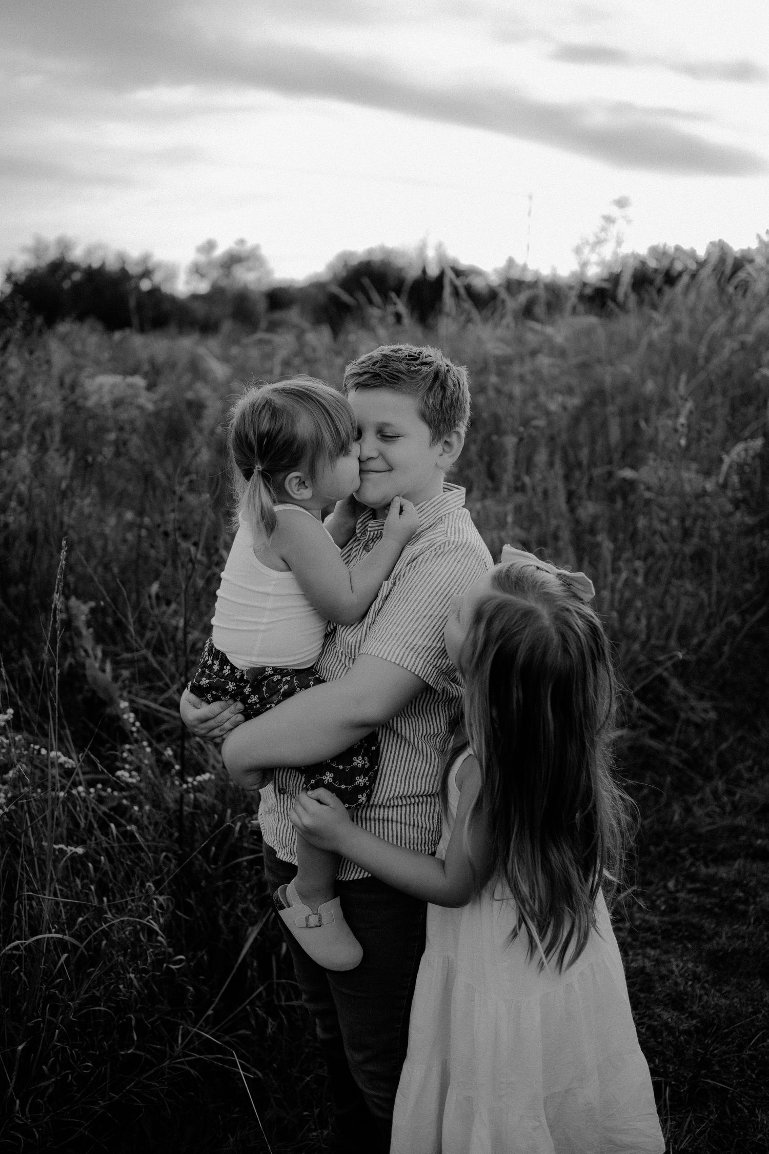 Big sister holding newborn baby during Lawrence Kansas newborn photography session