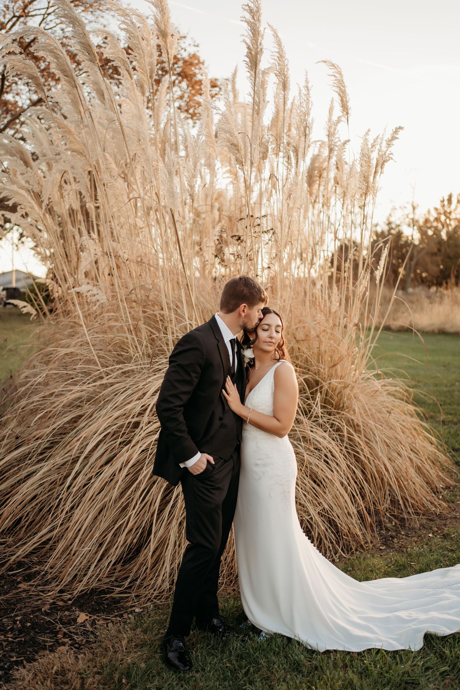 Bride and groom walking through field during Lawrence Kansas wedding photography session