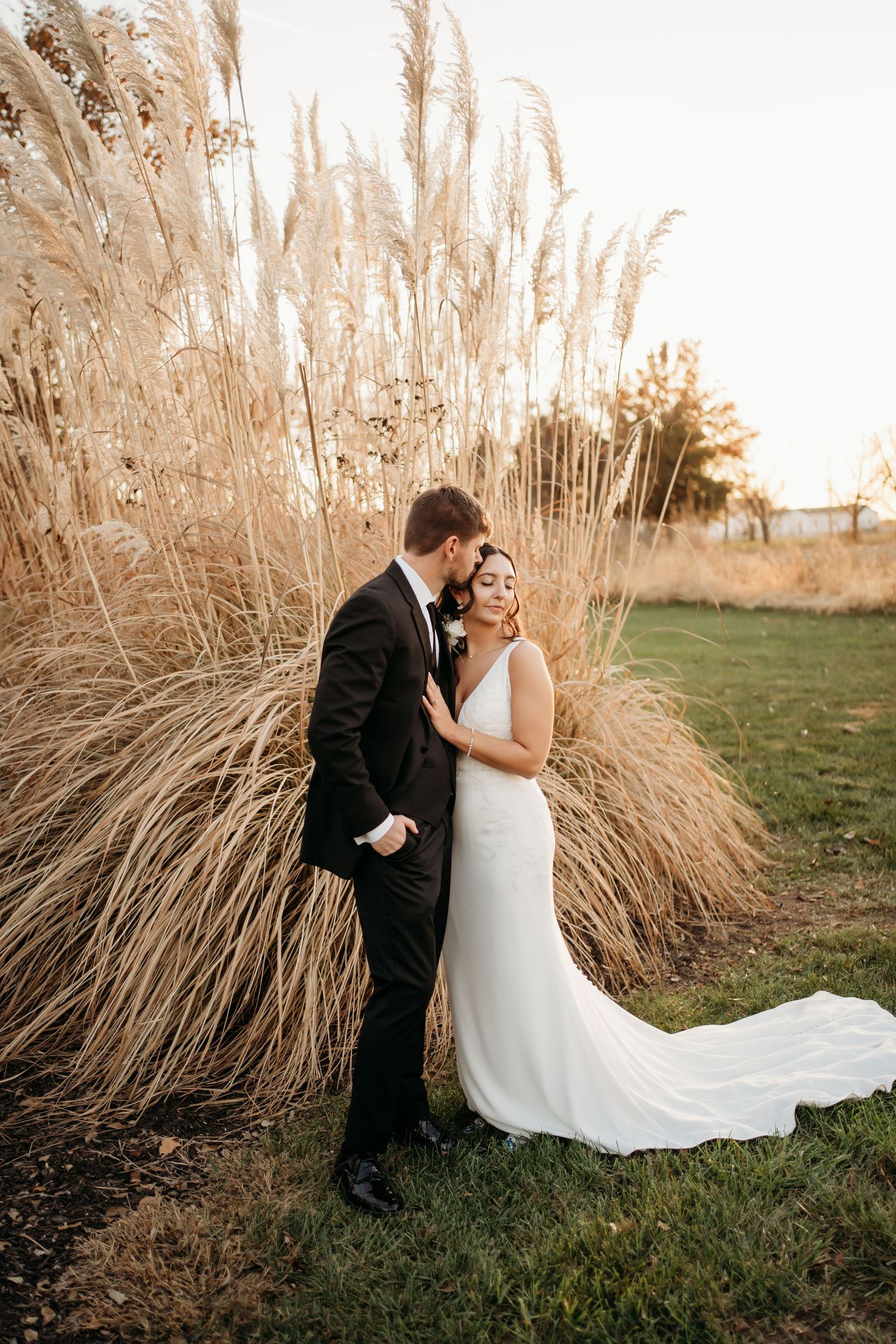 Bride and groom walking through field during Topeka Kansas wedding photography session