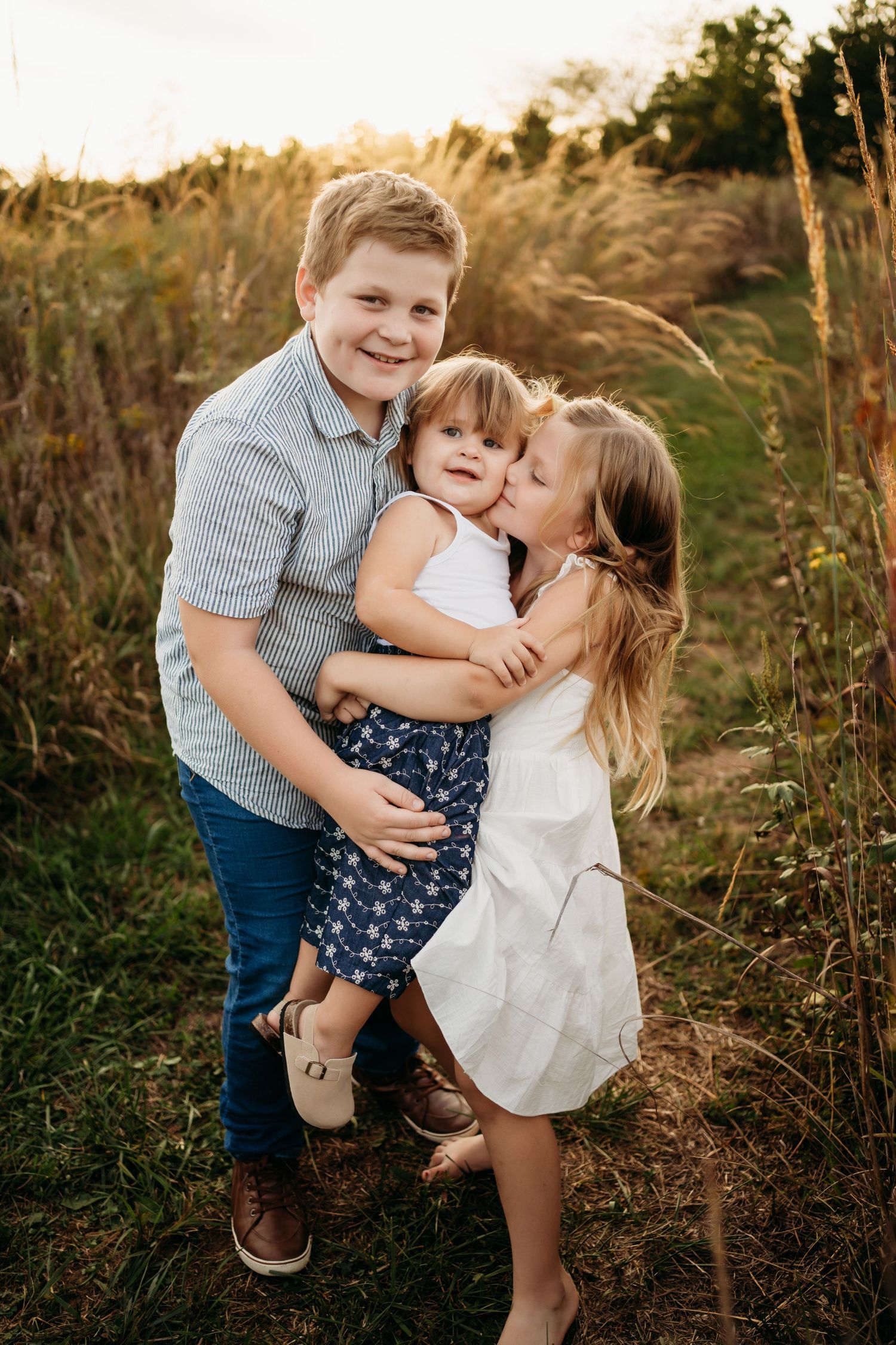 Big sister holding newborn baby during Lawrence Kansas newborn photography session