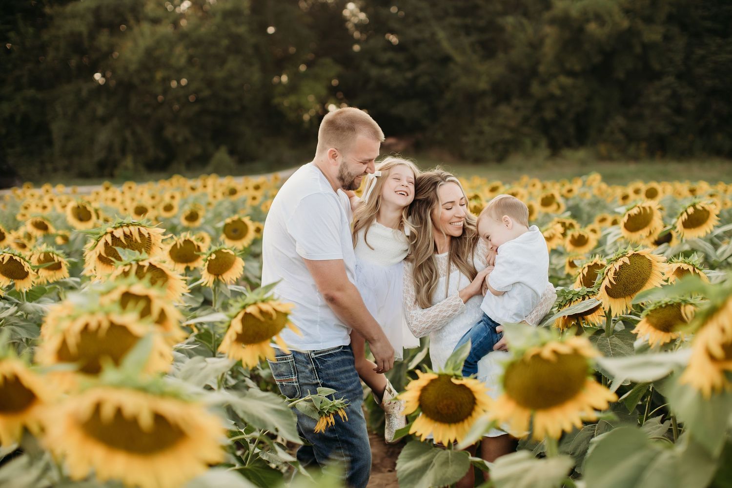 Kansas family photographer capturing parents and kids in sunflower field