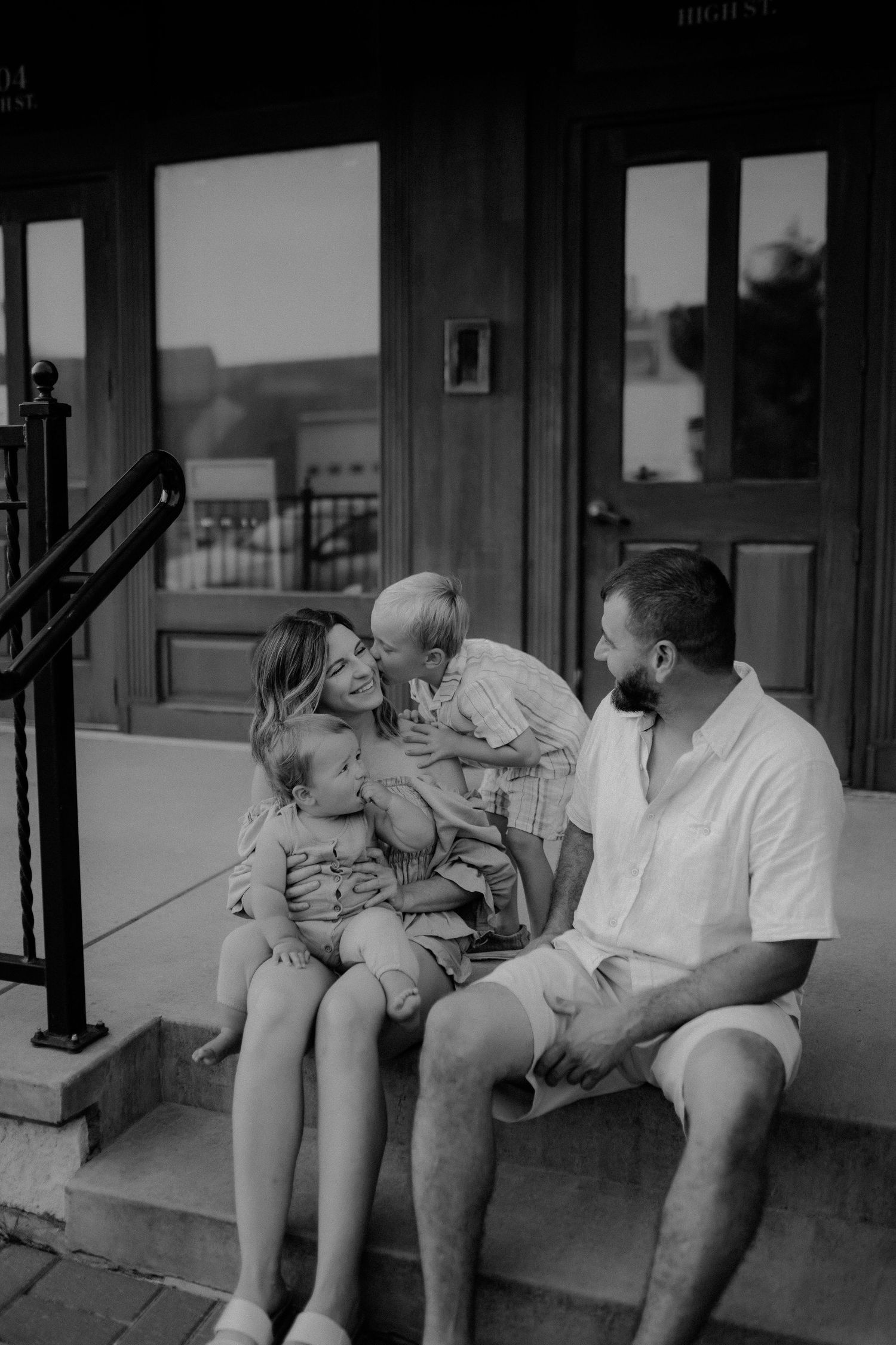 Family laughing together during outdoor family photo session in Lawrence Kansas