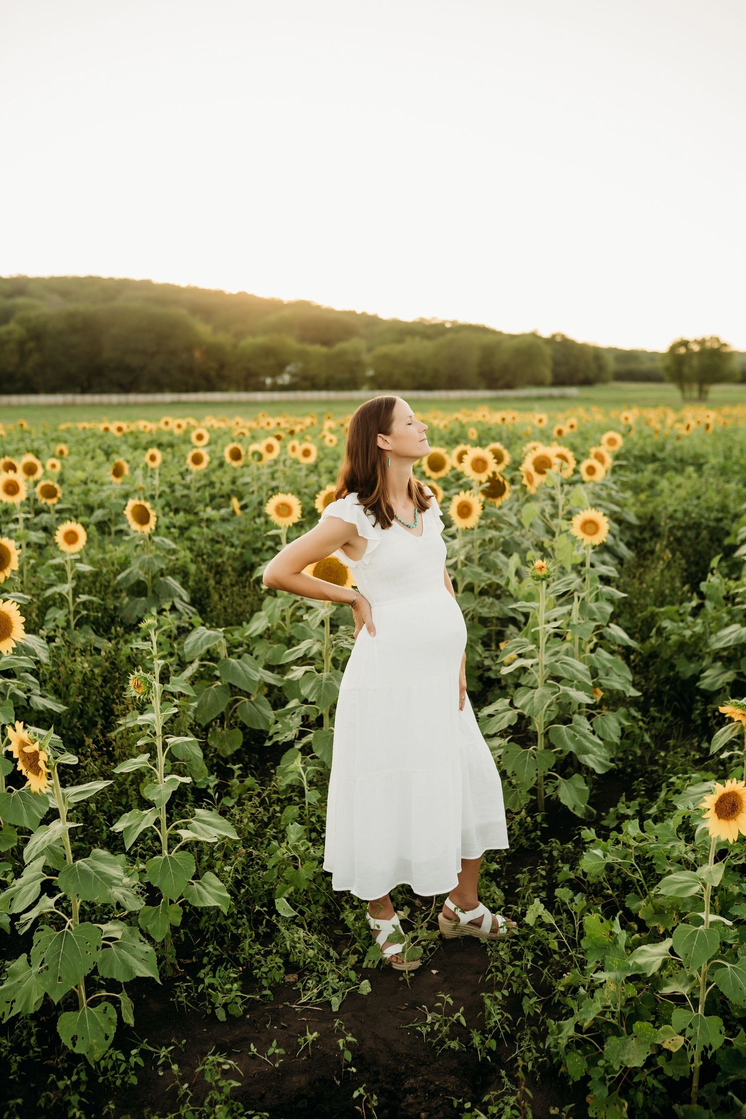 Family laughing together in sunflower field during Lawrence Kansas family photography session