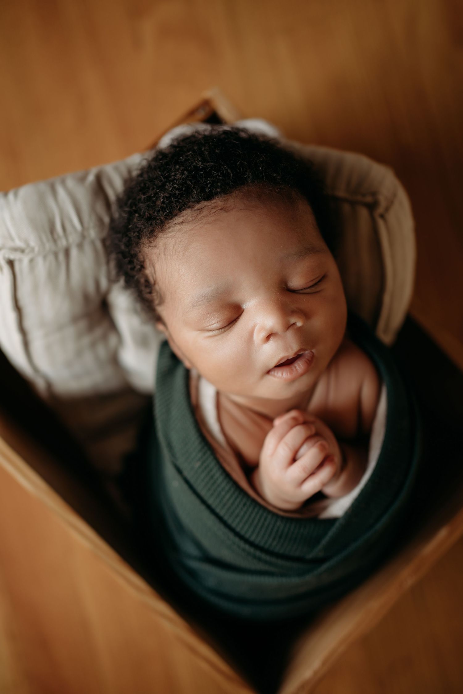 Sleeping newborn baby wrapped in blanket during Lawrence Kansas newborn photography session