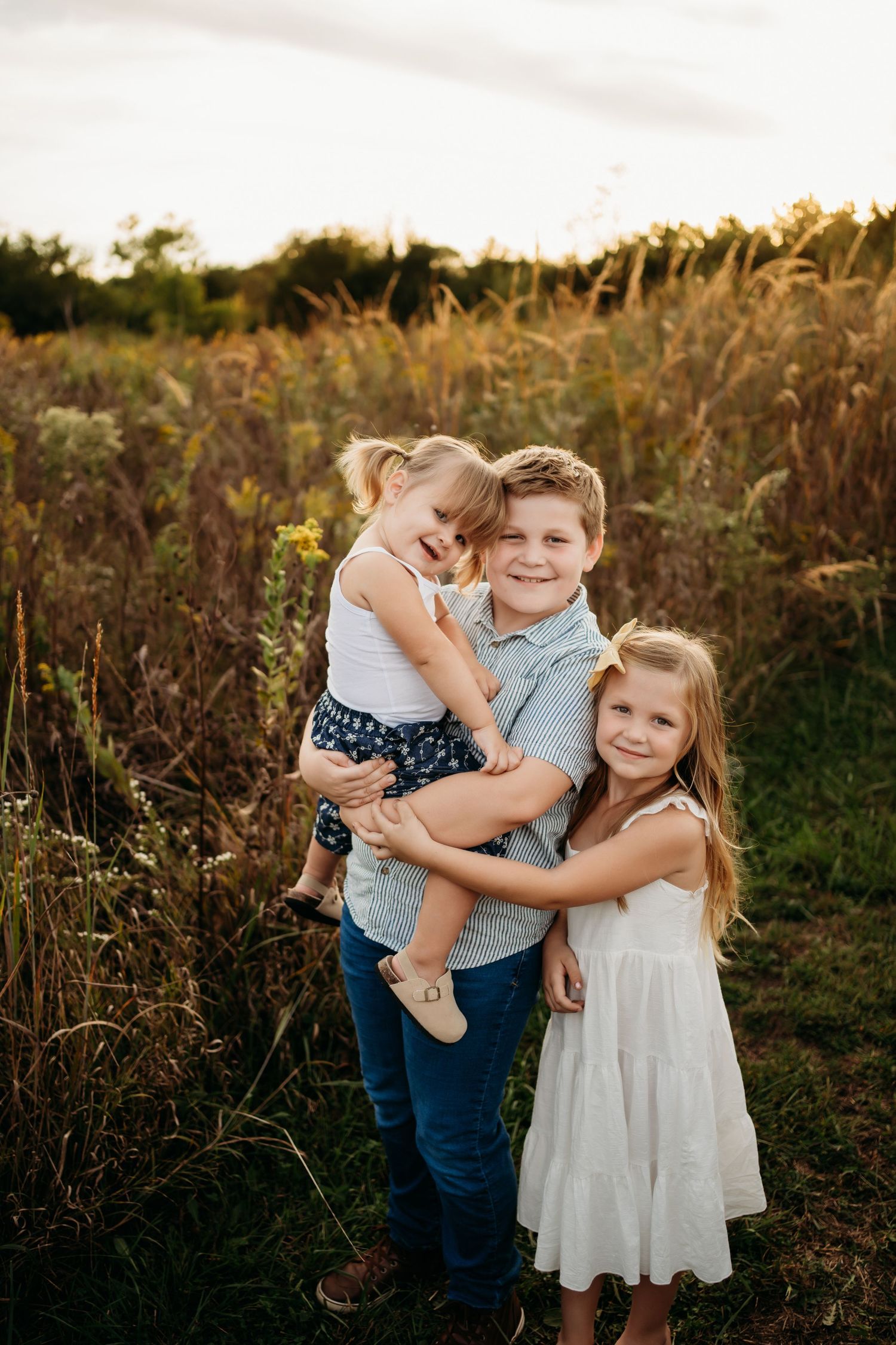 Big sister holding newborn baby during Lawrence Kansas newborn photography session