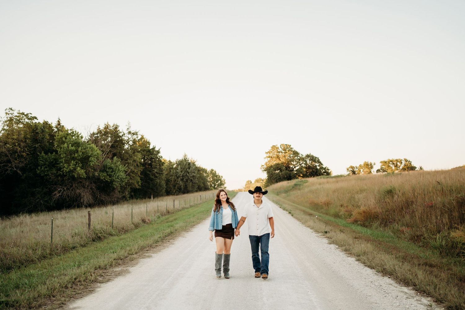 Bride and groom walking through field during Lawrence Kansas wedding photography session