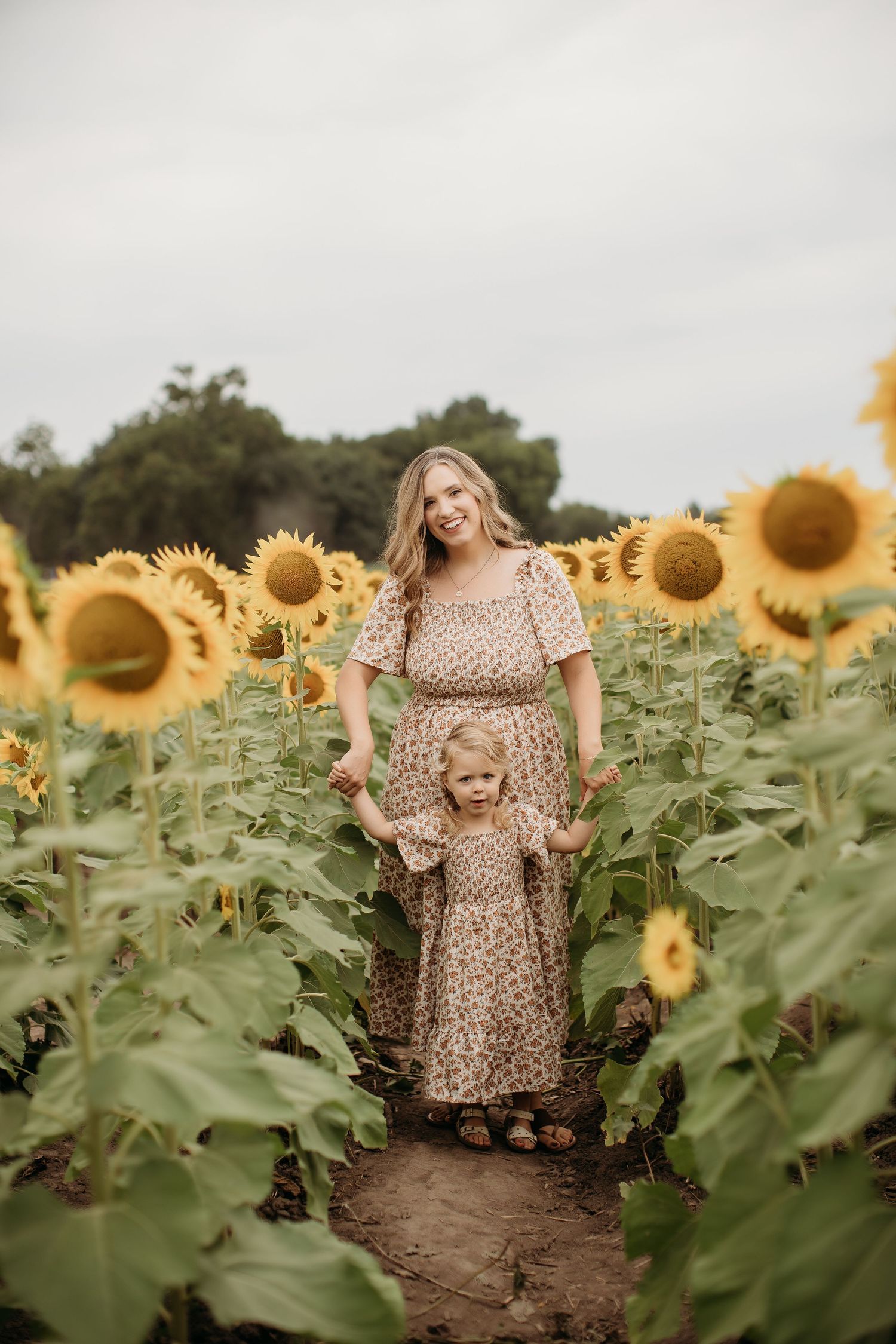 Family laughing together in sunflower field during Lawrence Kansas family photography session